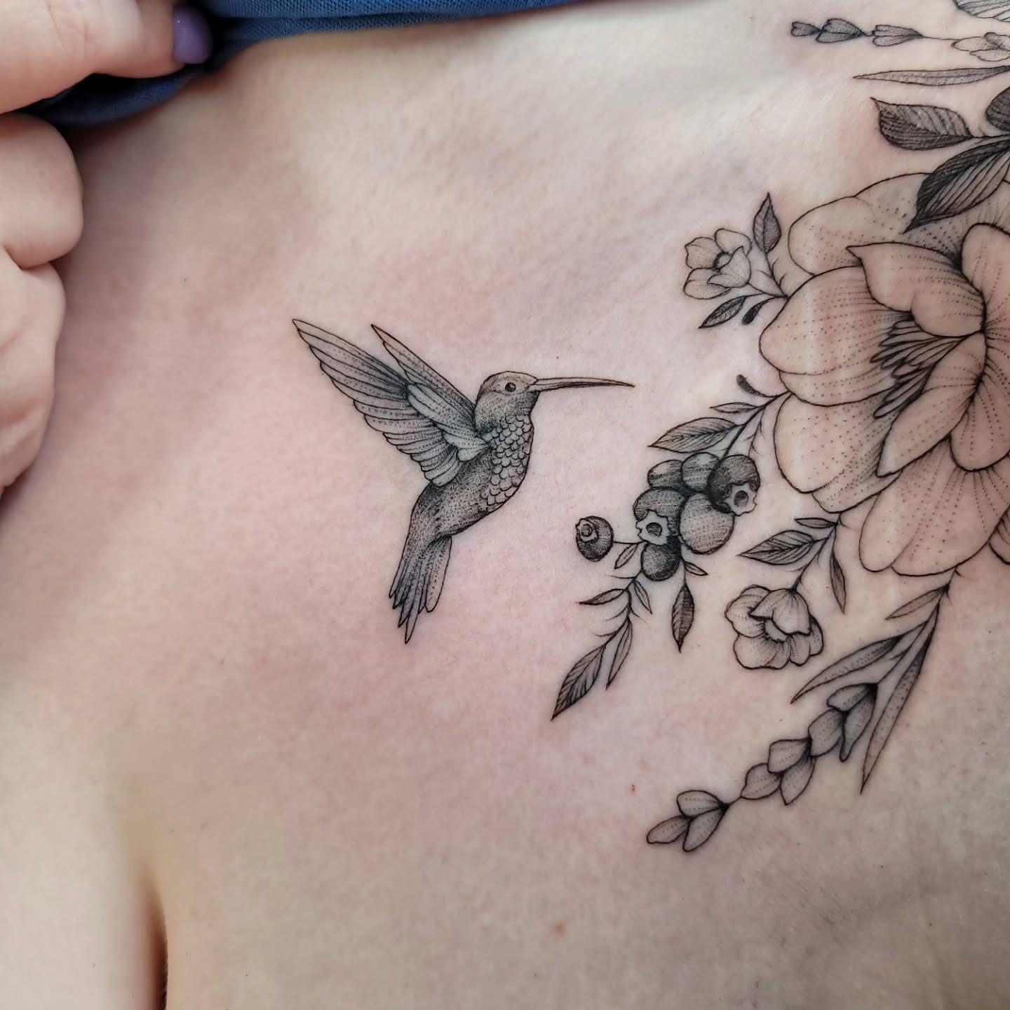 Hummingbird and floral bouquet realism tattoo on the chest by Mary Lefeau