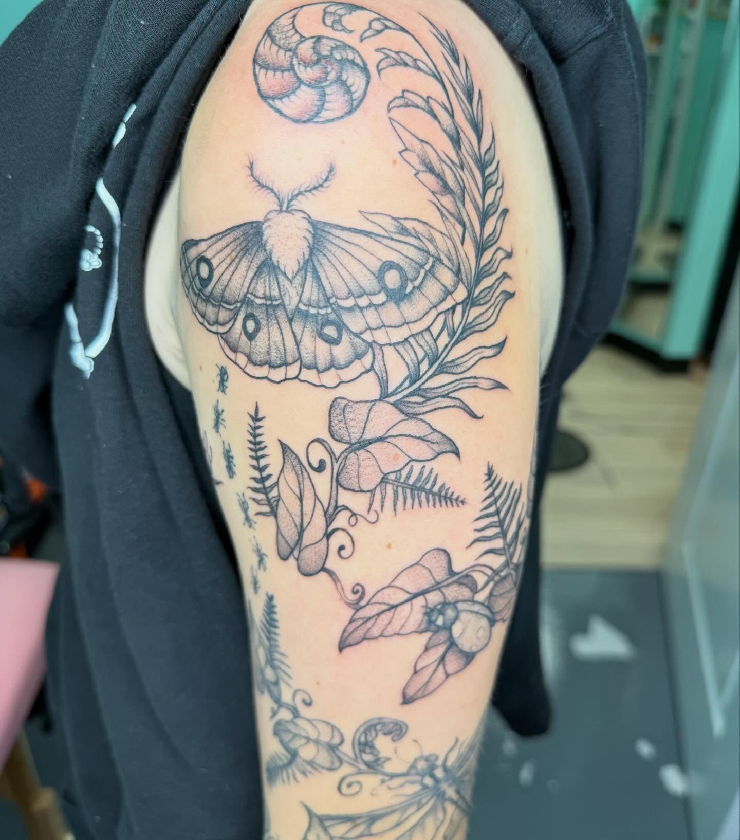 Moth and floral realism tattoo on the forearm by Bry