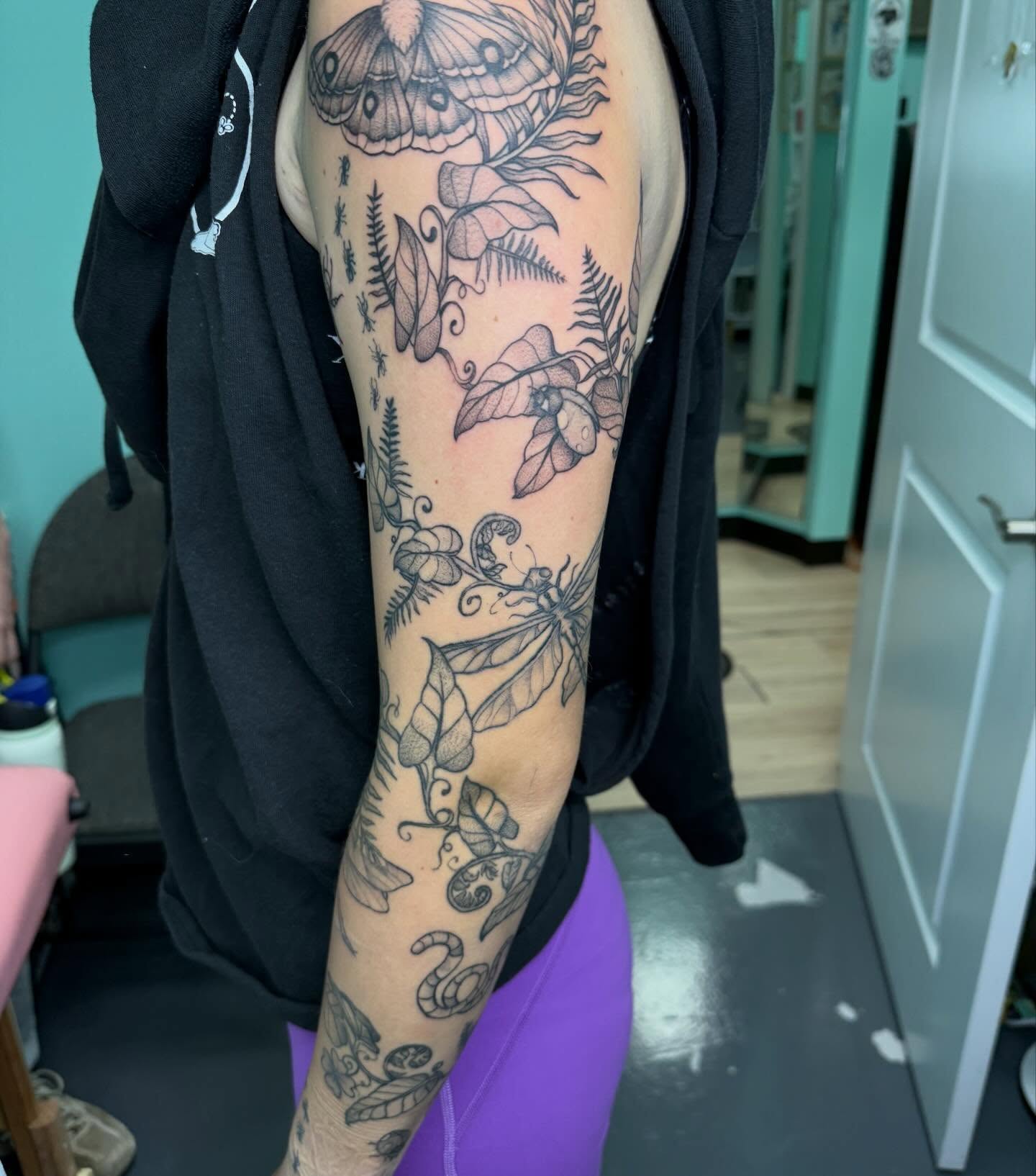 Botanical and insect motifs black and grey tattoo on the forearm by Bry