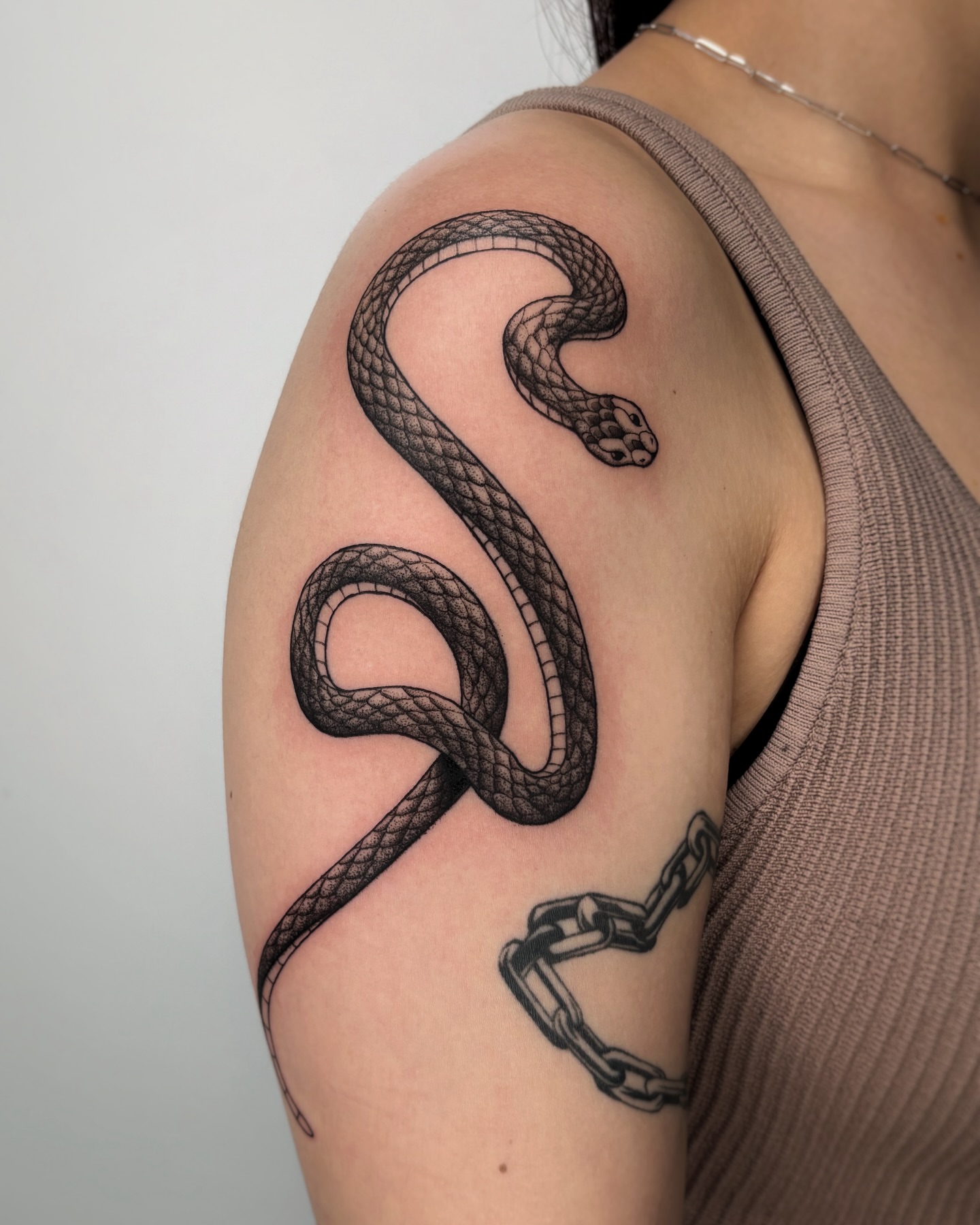 Snake black and grey tattoo on the shoulder by Kuya, Berkeley, California
