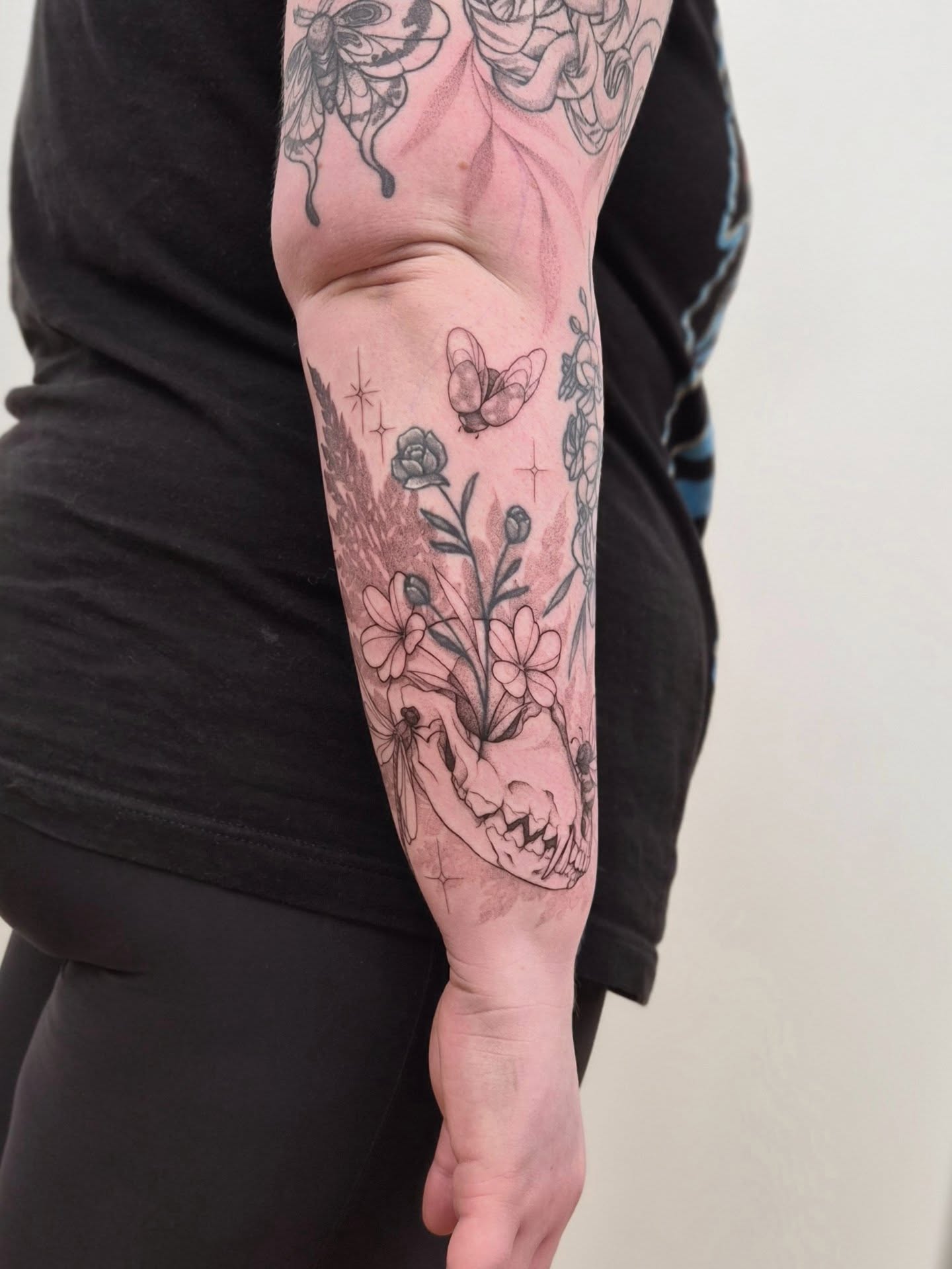 Floral arrangement with butterfly black and grey tattoo on the forearm by Sophorn Long (soapy)