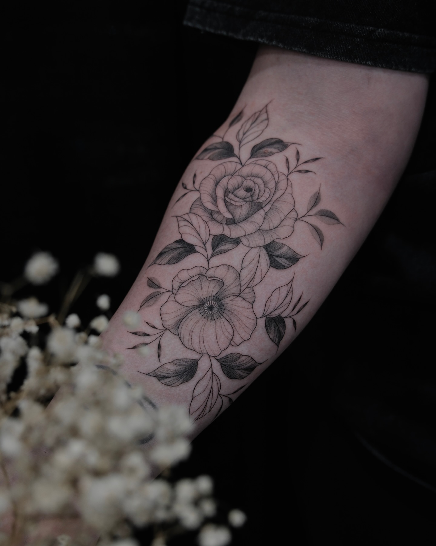 Floral bouquet black and grey tattoo on the forearm by Haley Sayers