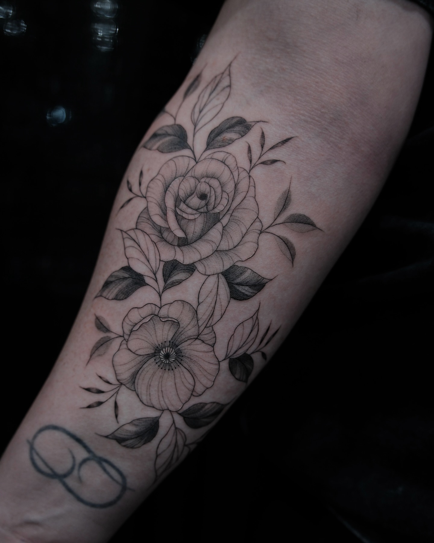Floral arrangement realism tattoo on the forearm by Haley Sayers