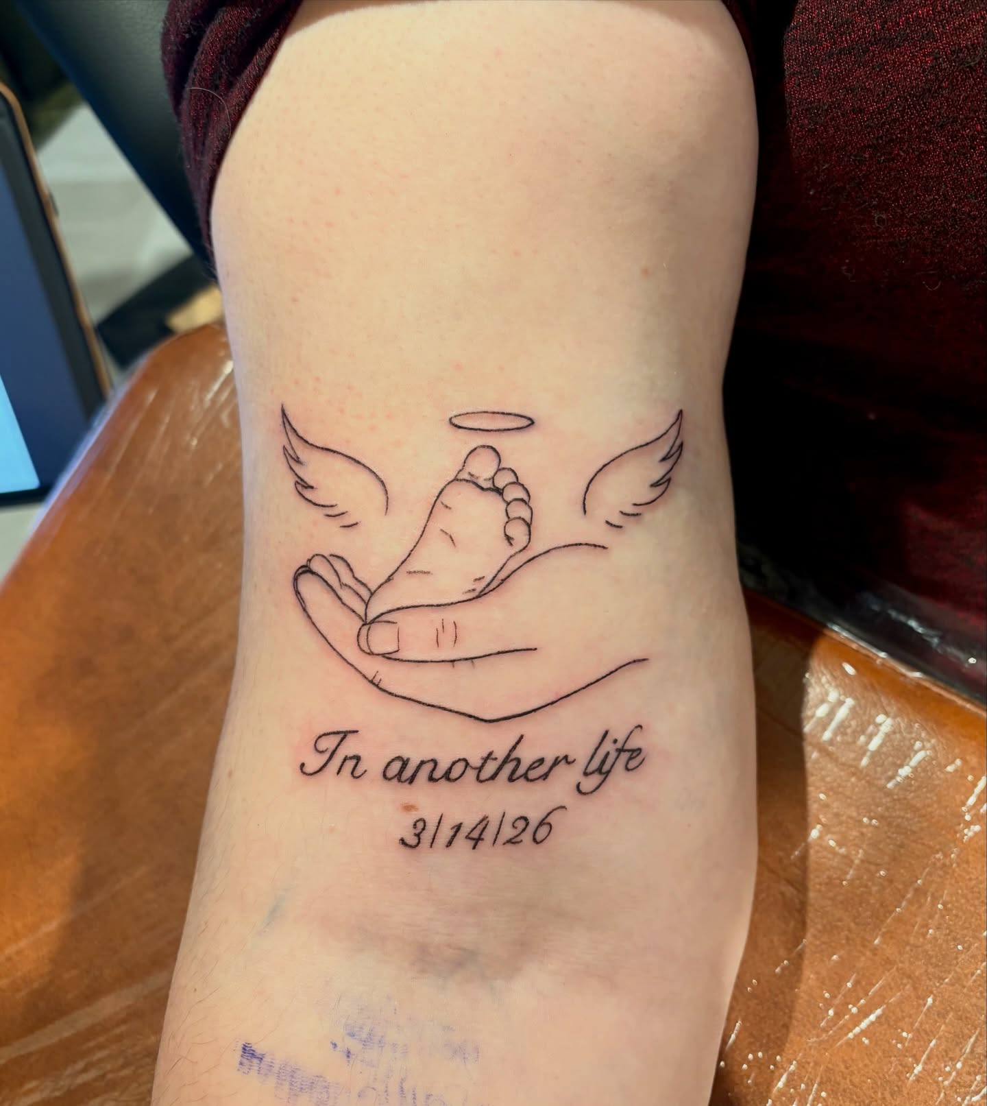 Baby foot with wings fine line tattoo on the forearm by Emily, Monticello, Iowa