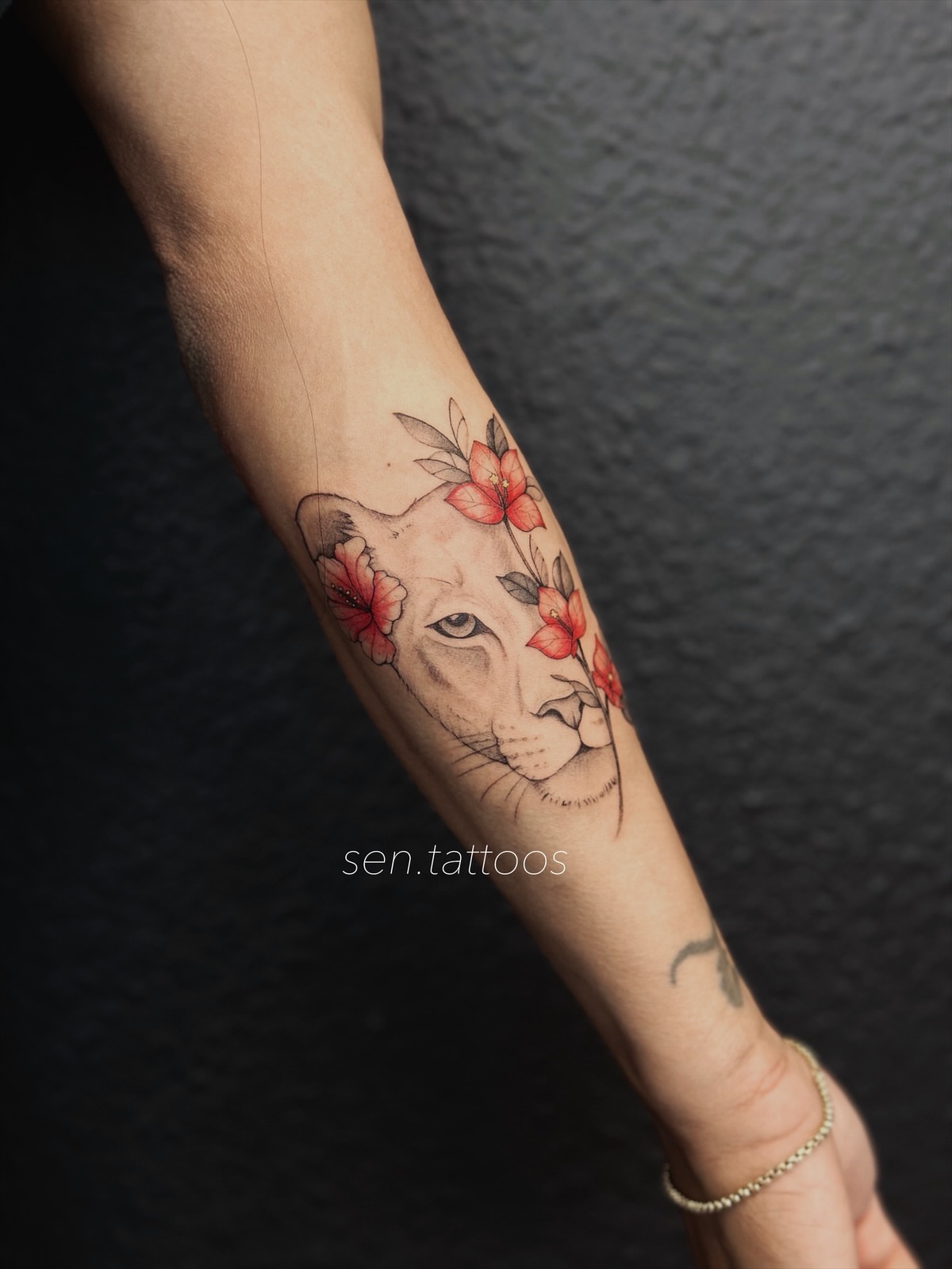 Lion with flowers realism tattoo on the forearm by Sen Tattooer