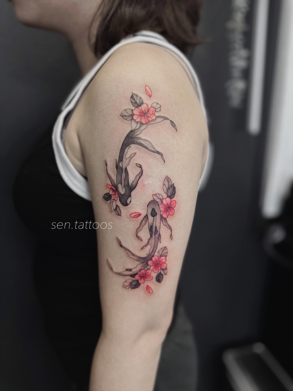 Koi fish and cherry blossoms watercolor tattoo on the forearm by Sen Tattooer