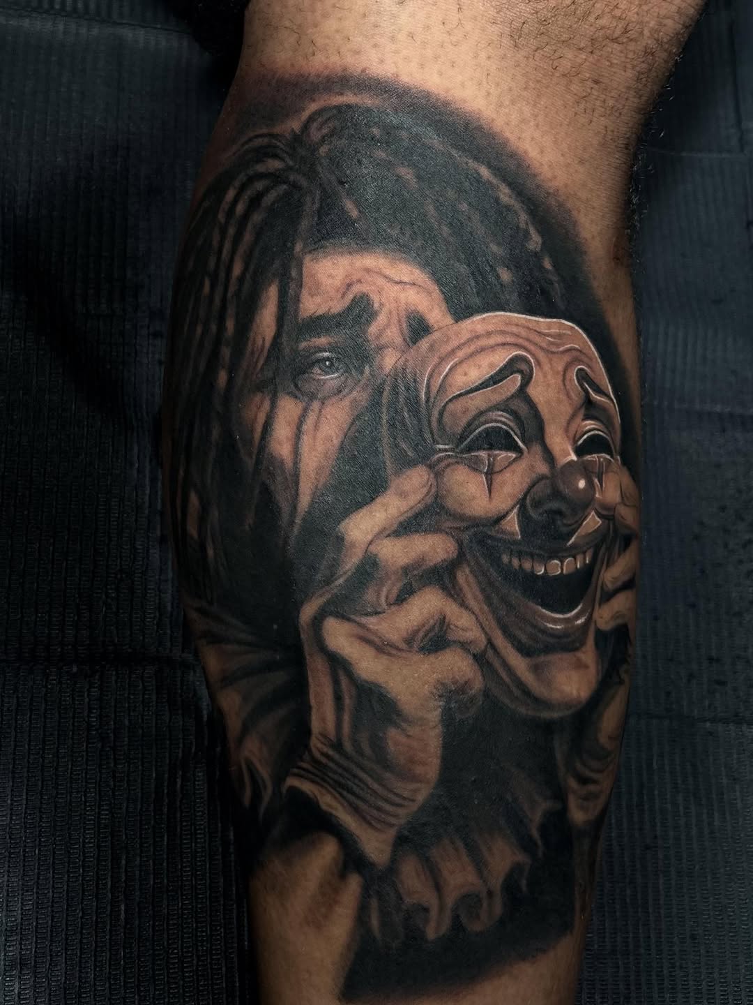 Person holding a smiling mask realism tattoo on the forearm by Jayden A