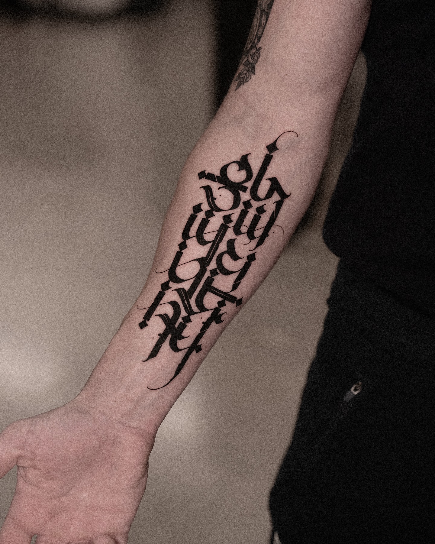 Gothic script lettering Chicano tattoo on the forearm by Low, Brooklyn, New York
