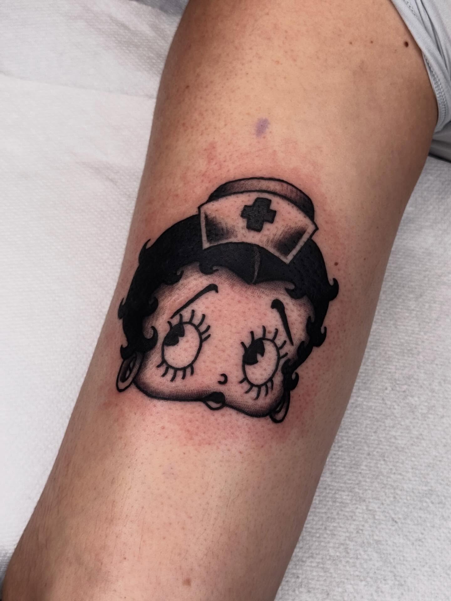 Betty Boop nurse black and grey tattoo on the forearm by Meg Nefcy, Milford, Michigan
