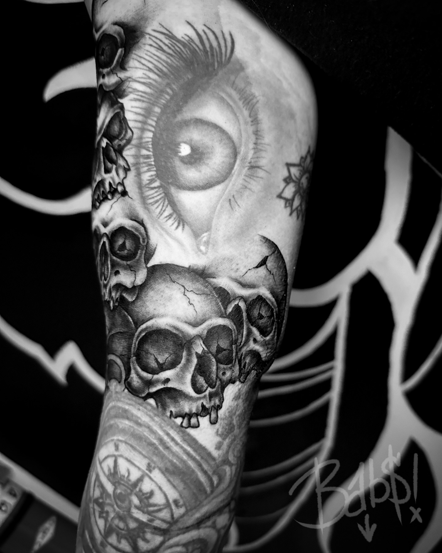 Eye and skulls realism tattoo on the forearm by Justin B