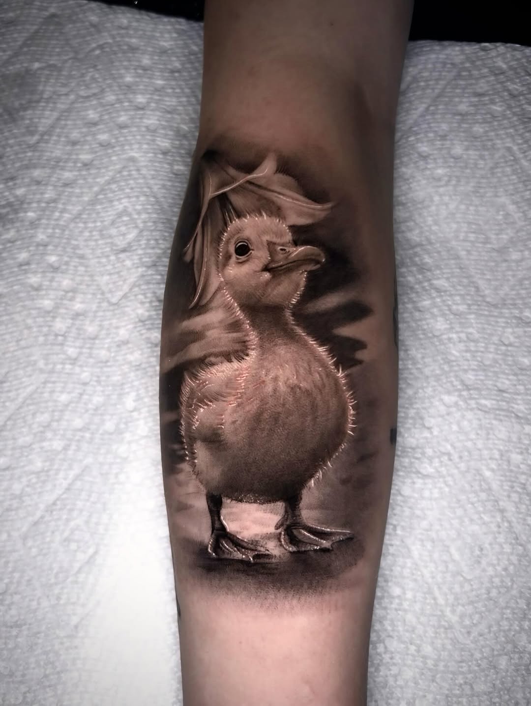 Duckling and flower fine line tattoo on the forearm by Dallas Corsmeier
