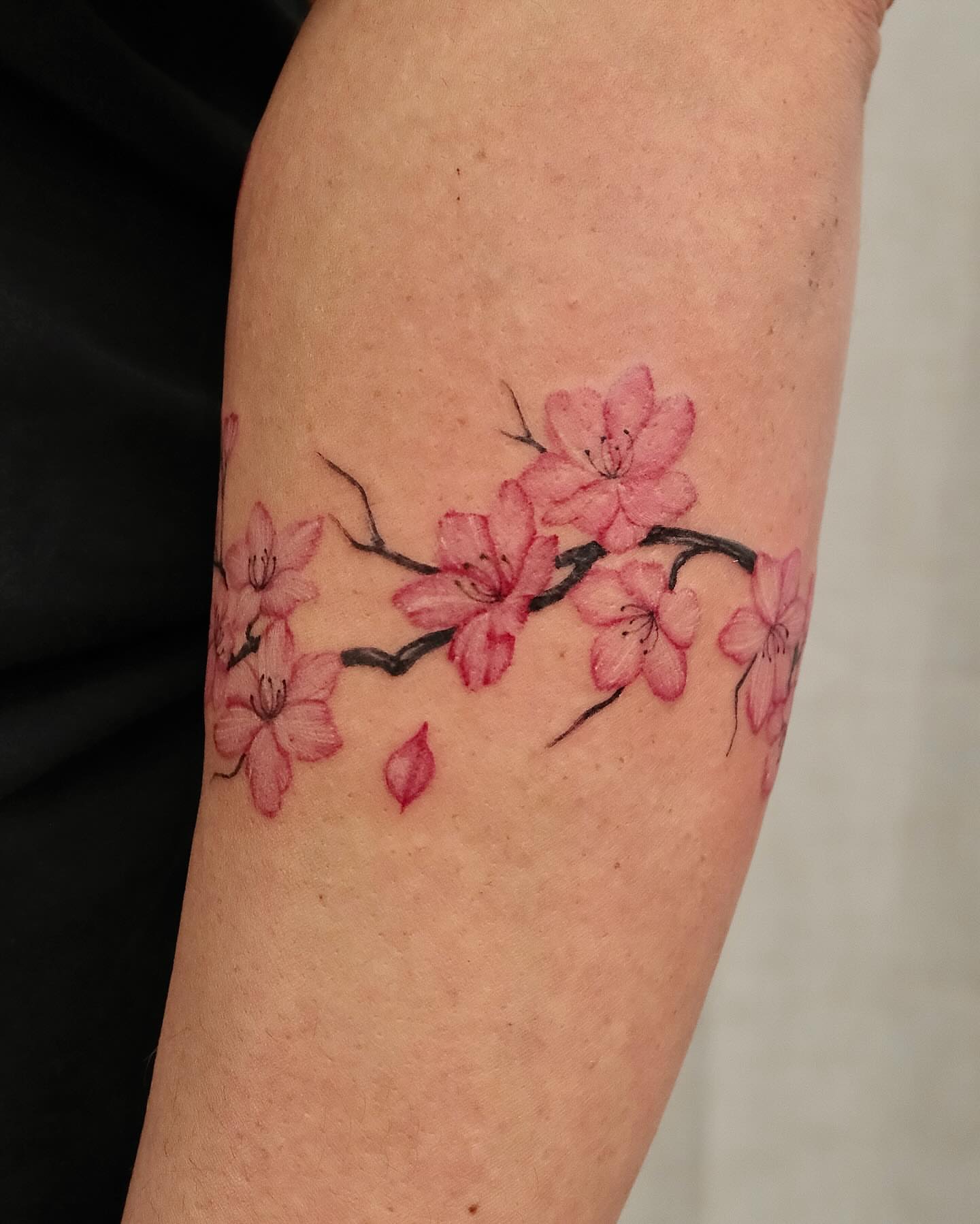 Cherry blossoms realism tattoo on the forearm by Koko