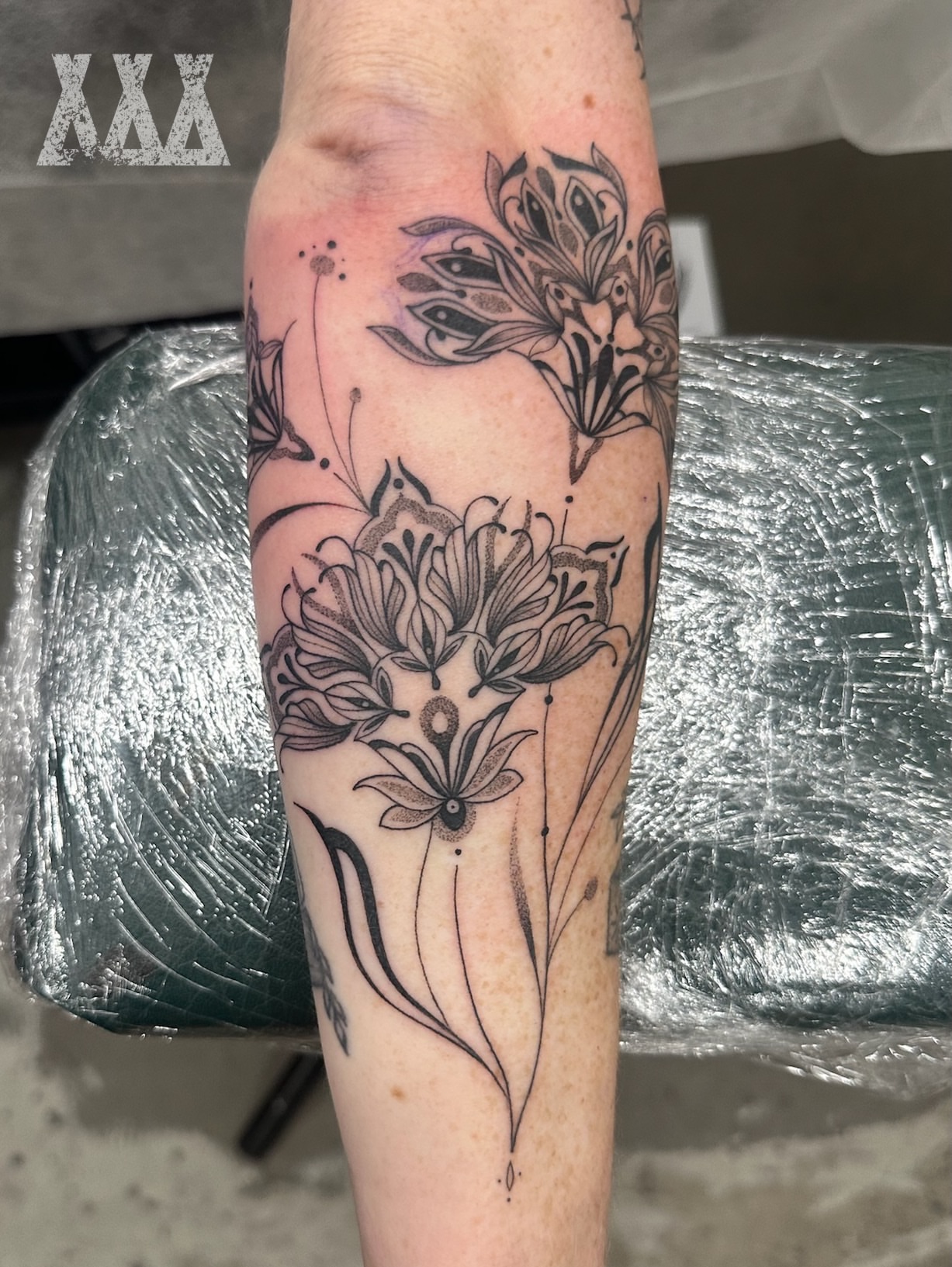 Floral arrangement black and grey tattoo on the forearm by Lyndsay Southgate