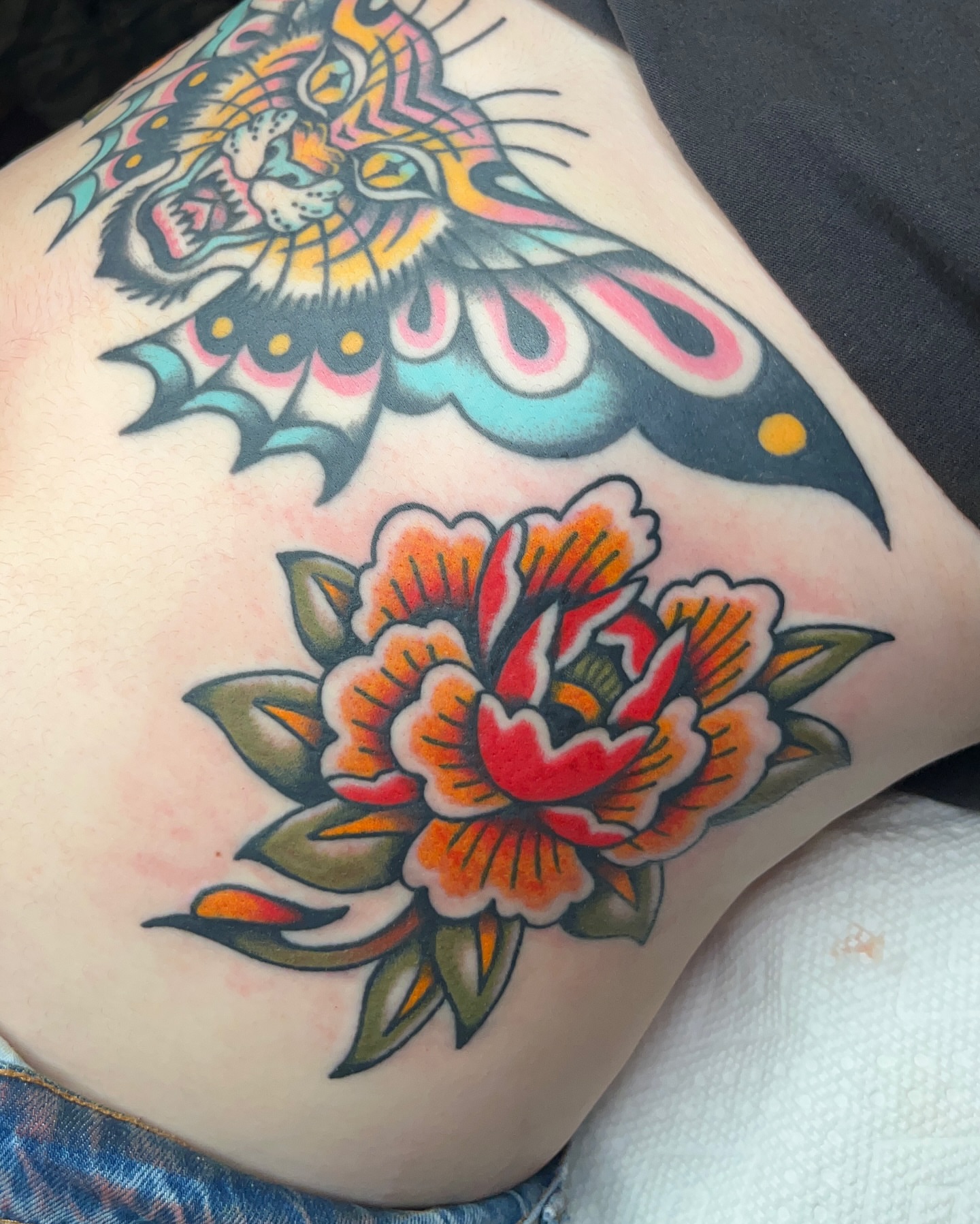 Tiger and flower American traditional tattoo on the thigh by Nat Power