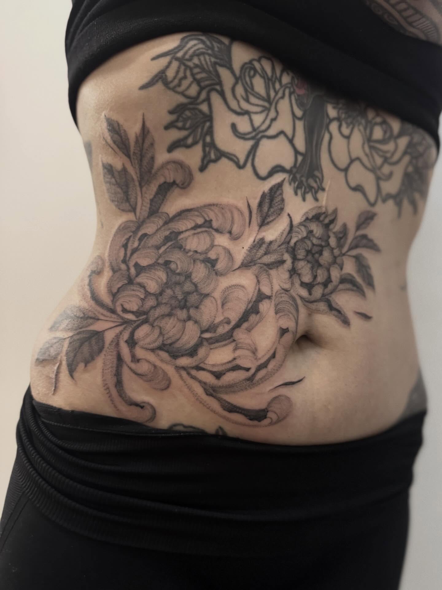 Peony and floral arrangement black and grey tattoo on the torso by Tianna Osborne