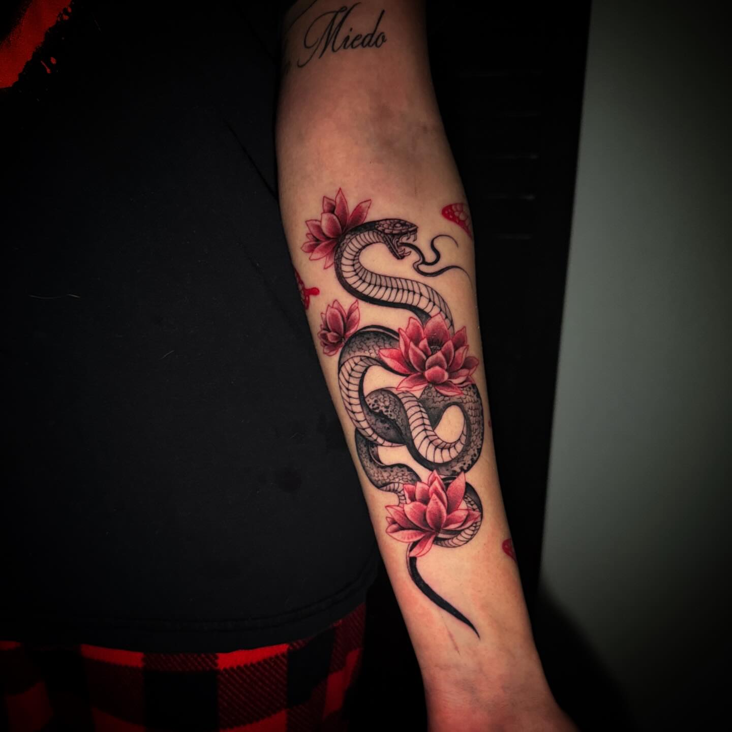 Snake and lotus flowers realism tattoo on the forearm by Sad Girl Tattoos