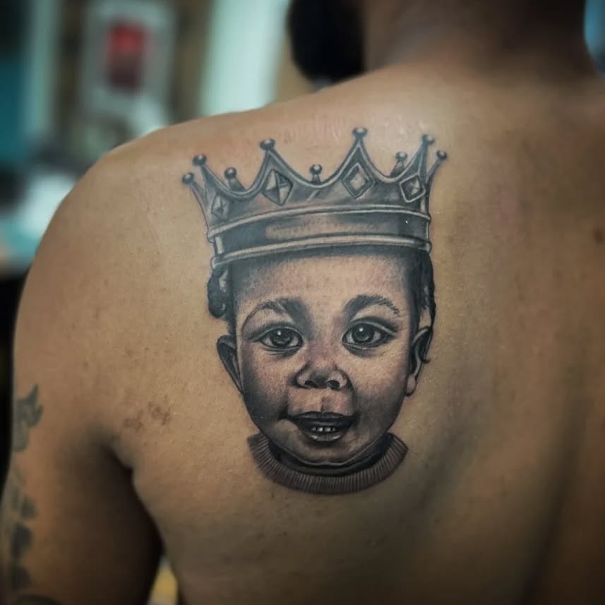 Baby portrait with crown realism tattoo on the back by Watson Gutkowski