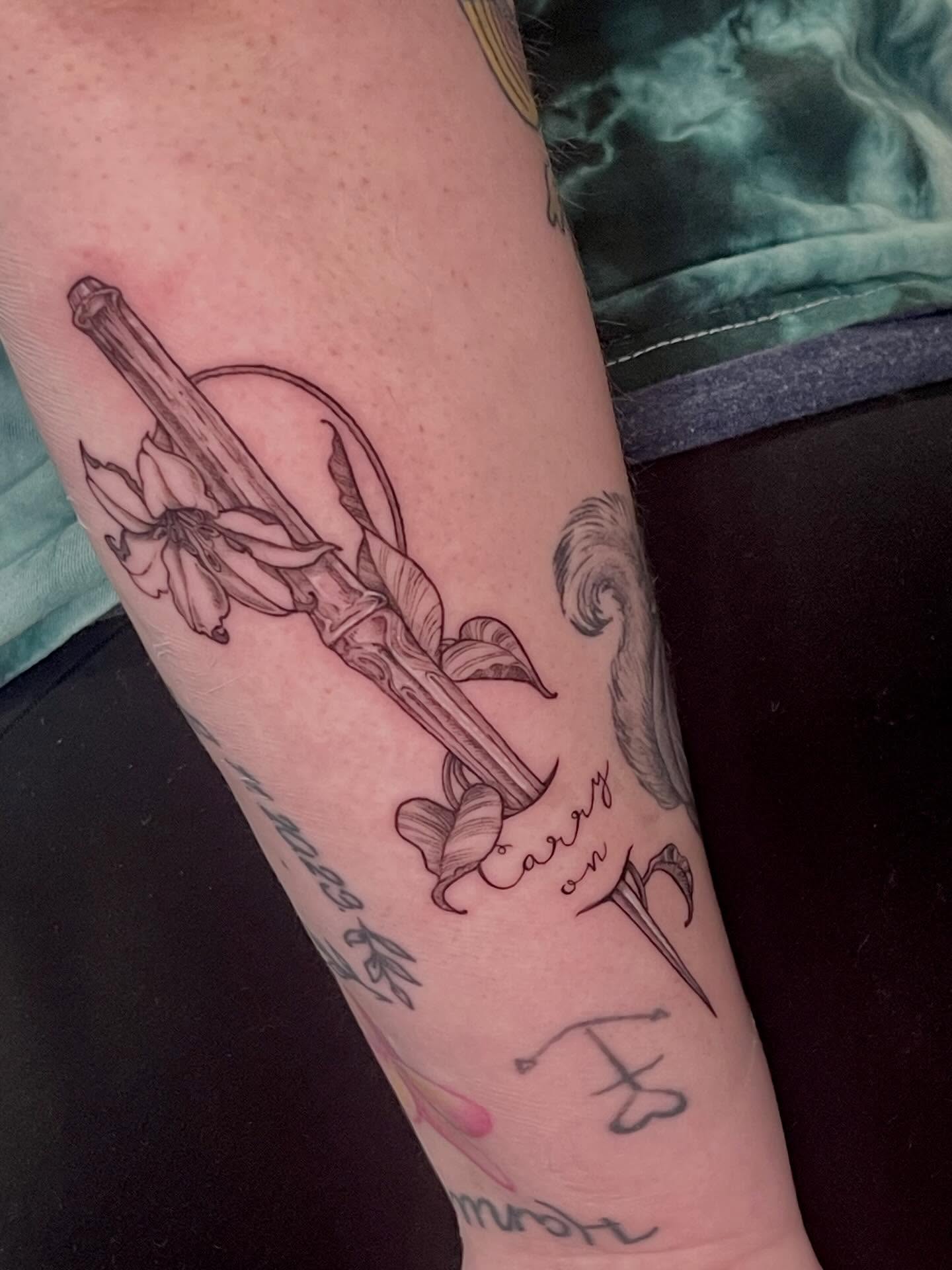 Sword and flower black and grey tattoo on the forearm by Sam DiBiase