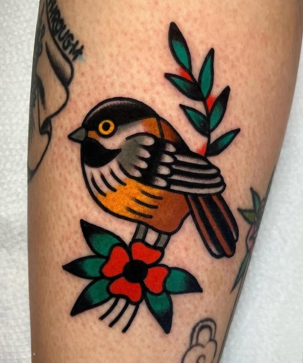Bird and flower American traditional tattoo on the forearm by Traditional Tattooing