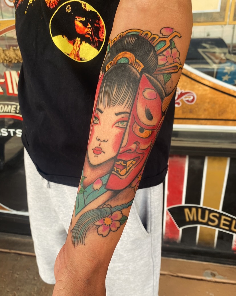 Geisha and mask American traditional tattoo on the forearm by Nick Weaver