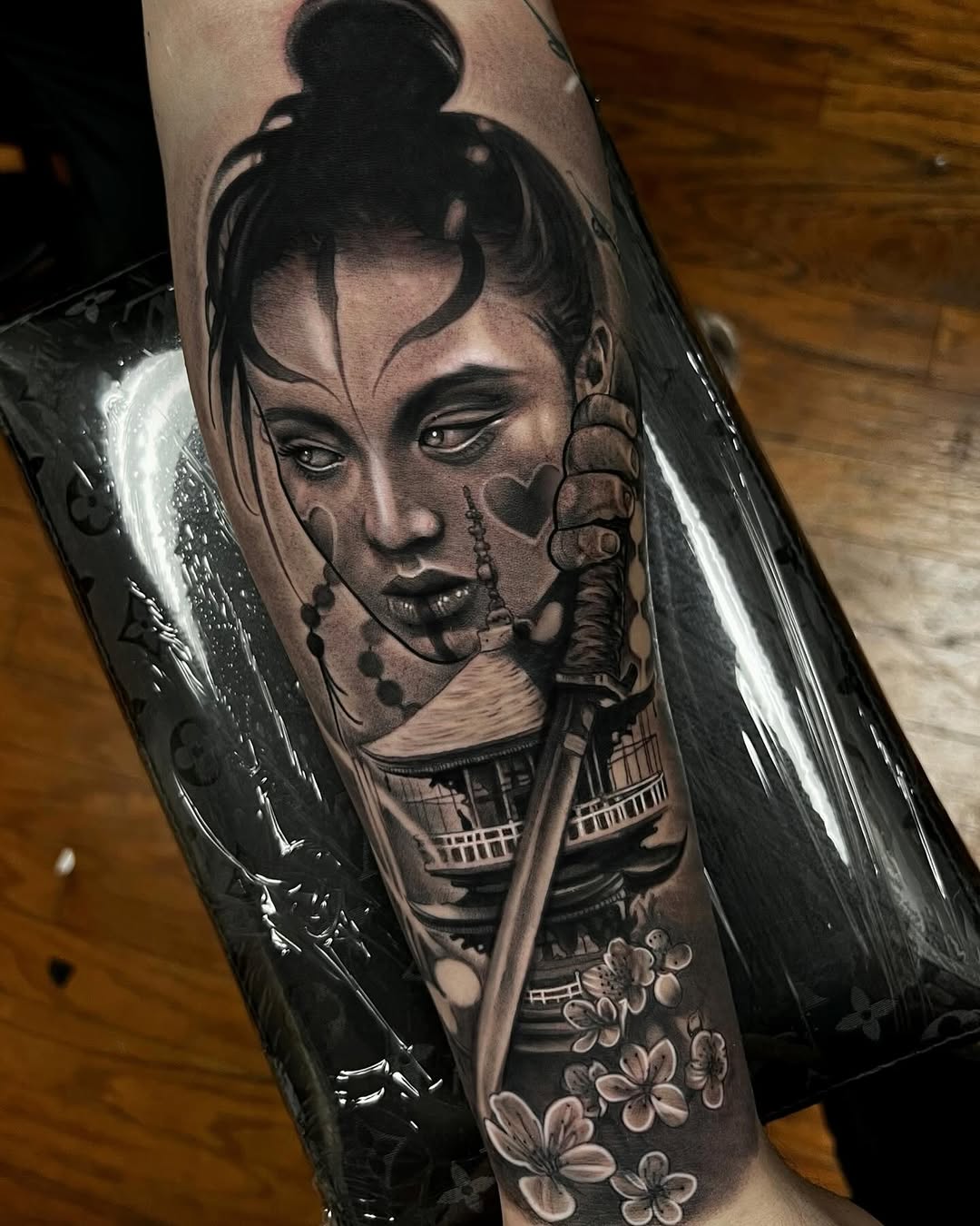 Geisha with sword and pagoda realism tattoo on the forearm by Jayden A
