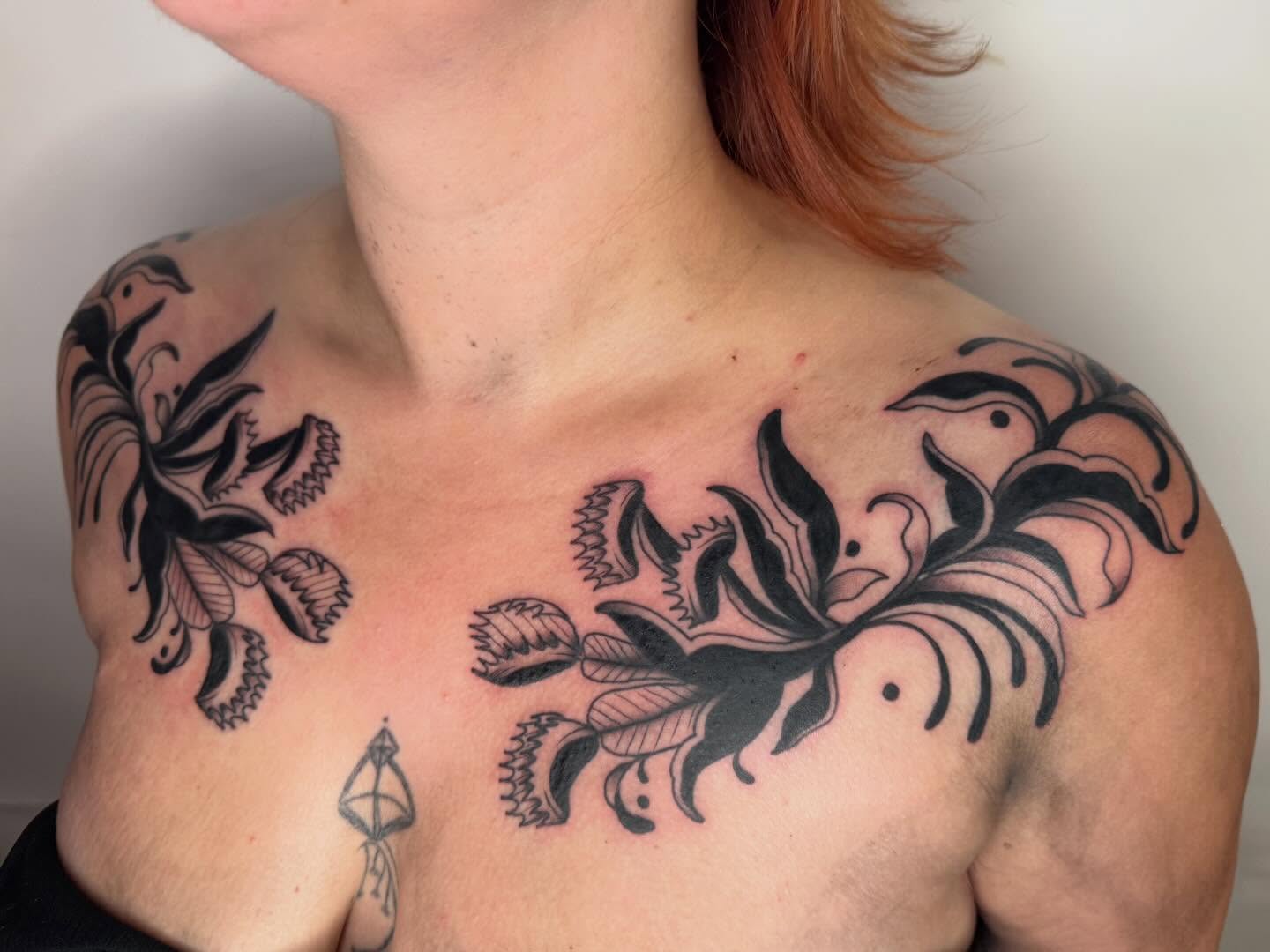 Floral design black and grey tattoo on the chest by Jacqui Rose