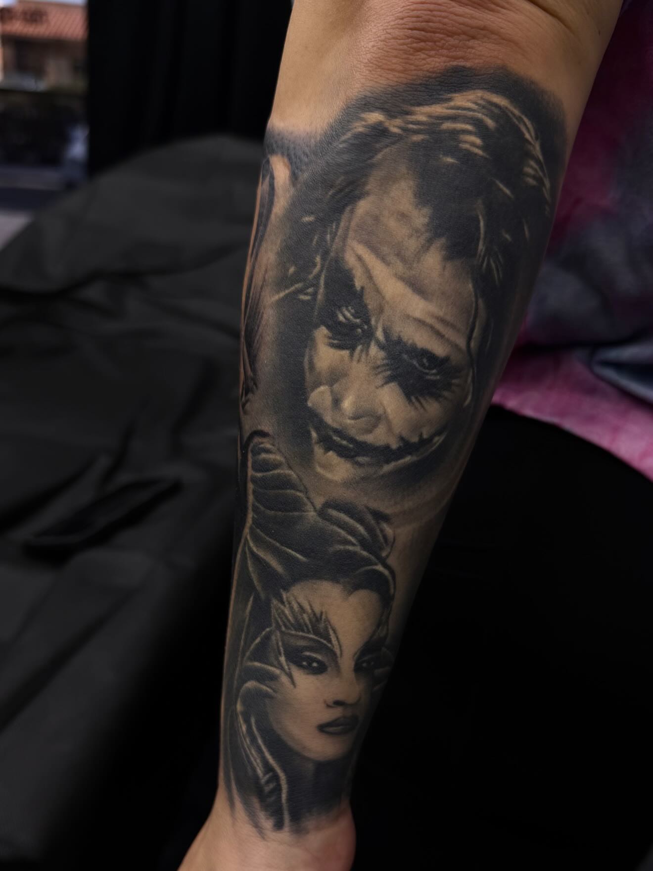 Joker and woman realism tattoo on the forearm by TattooBoyTattoos