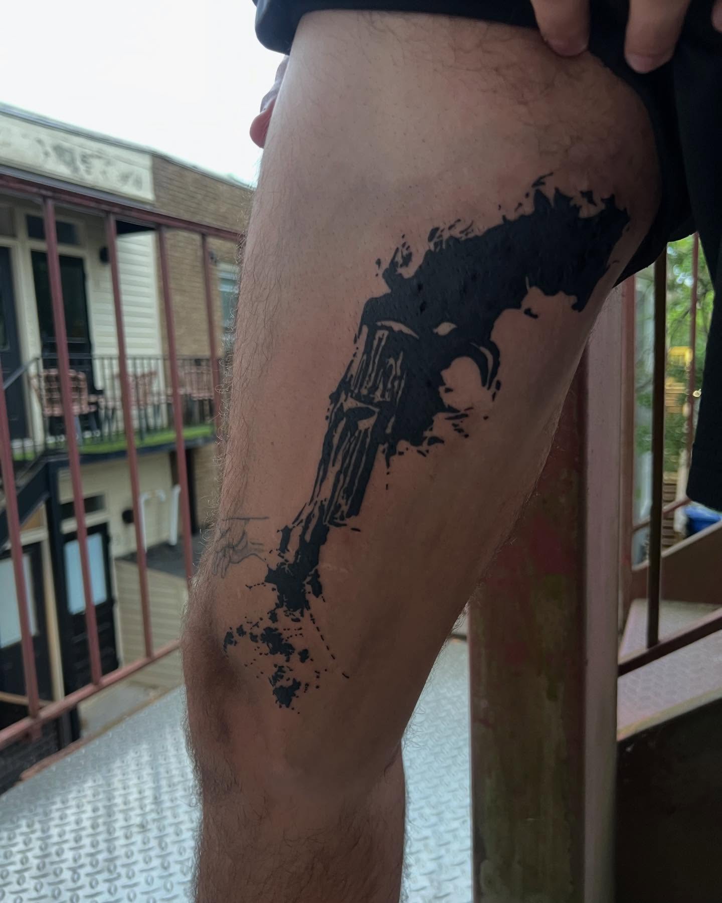 Gun black and grey tattoo on the thigh by Adam