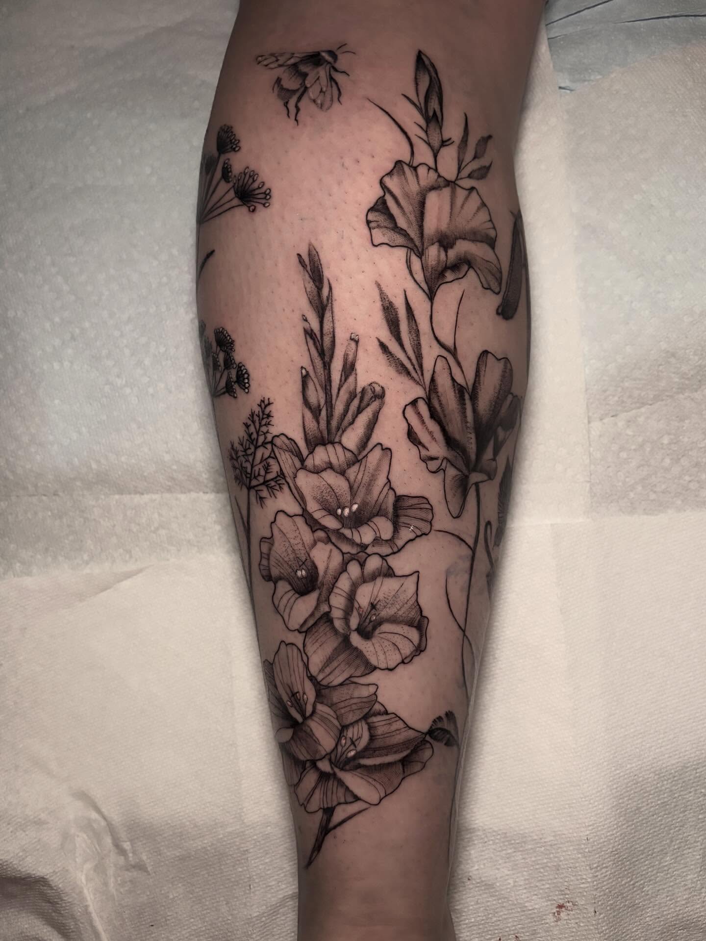 Flowers and bees realism tattoo on the forearm by Ashley Denise
