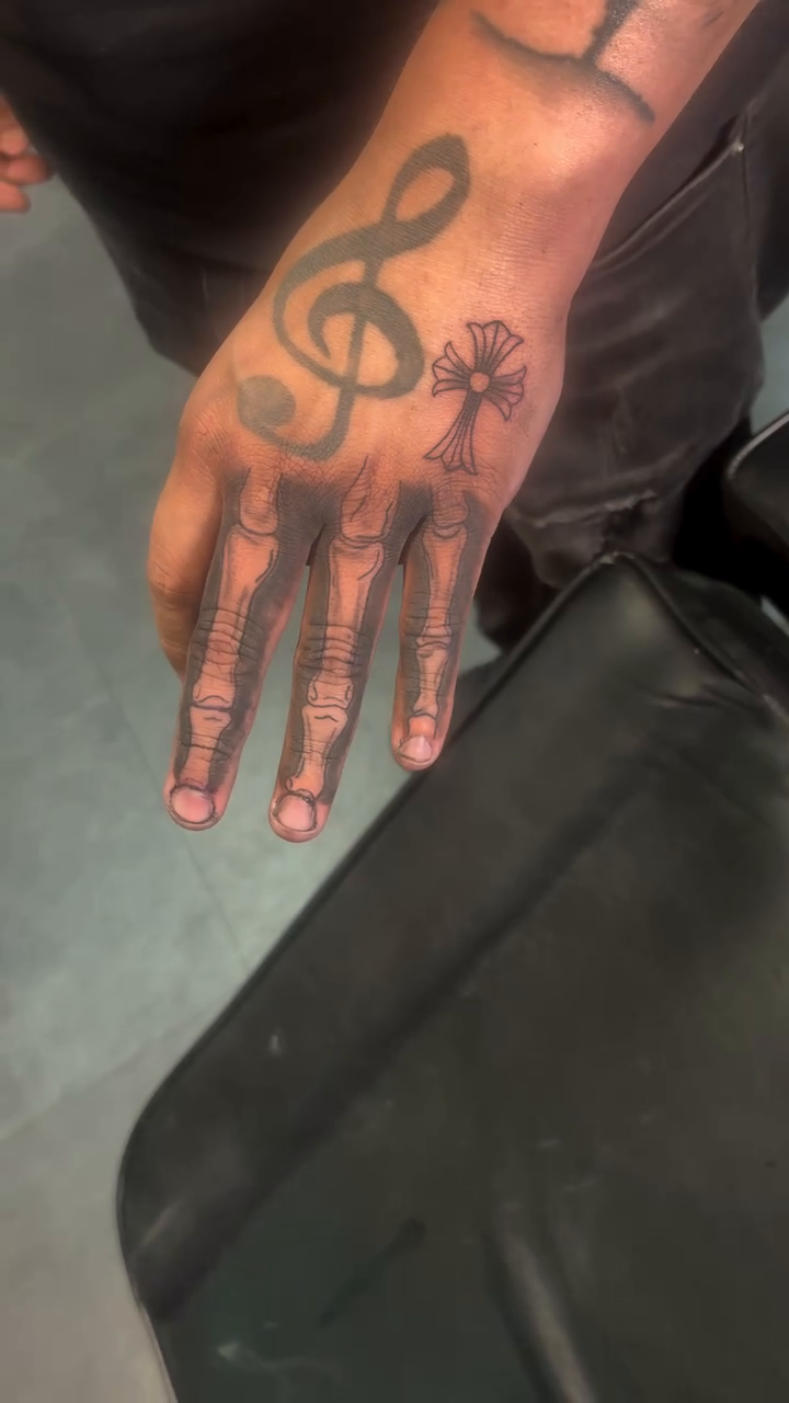 Treble clef and skeleton hand tattoo on the hand by TP