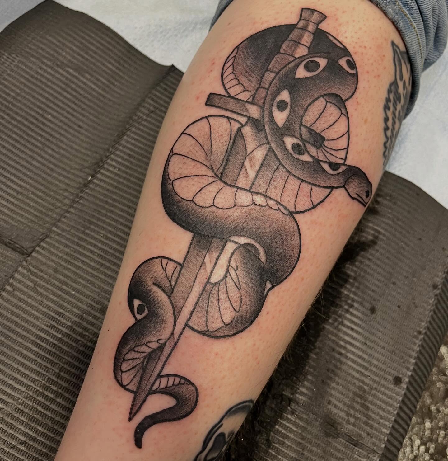 Snake and dagger black and grey tattoo on the forearm by Ian White