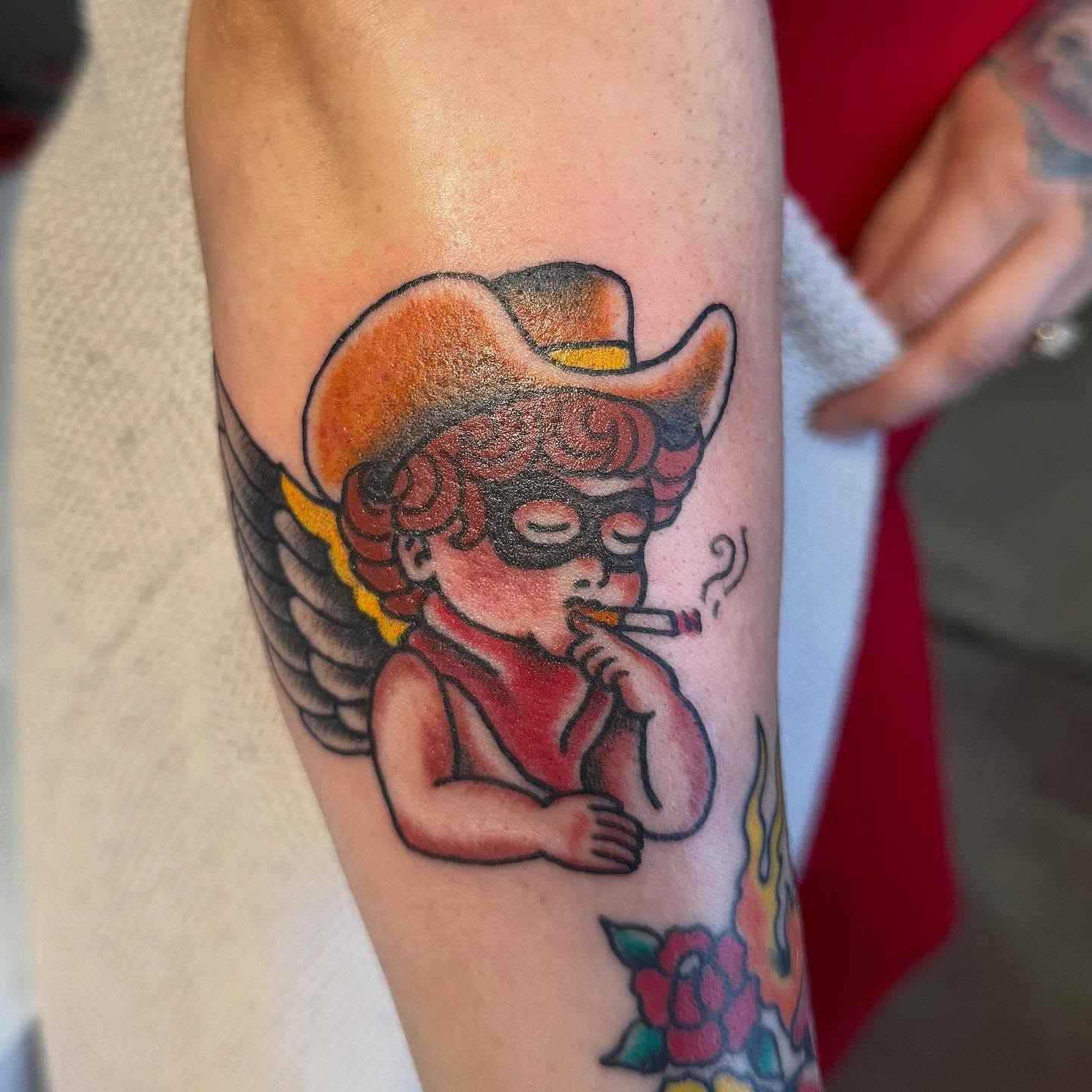 Smoking cherub American traditional tattoo on the forearm by Spencer Coco