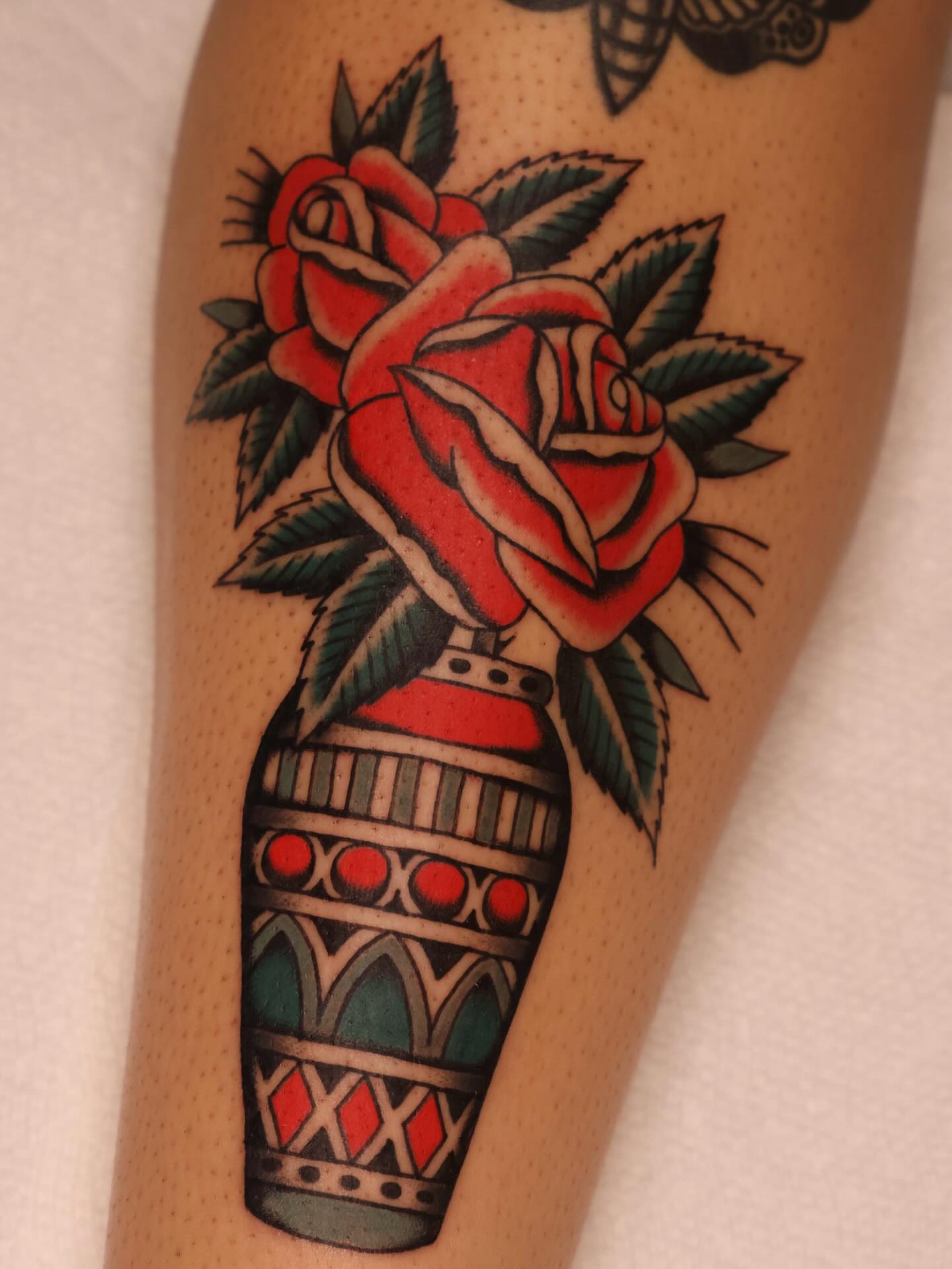 Roses in vase American traditional tattoo on the forearm by Justin Rakowski