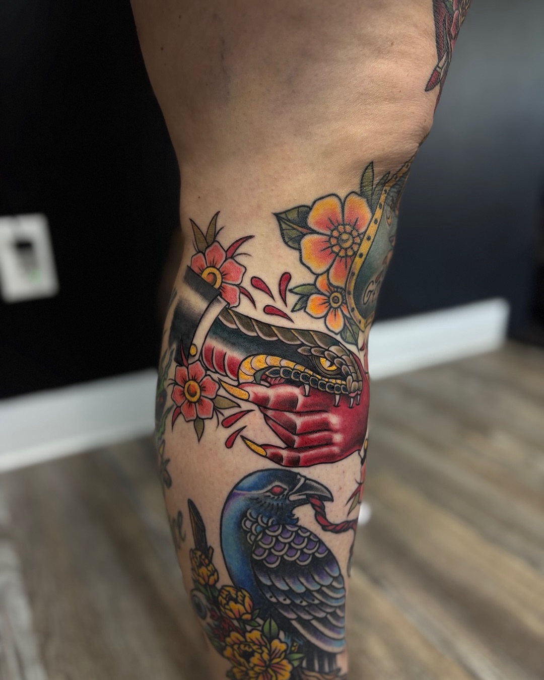 Snake and flowers American traditional tattoo on the forearm by Shiann Null