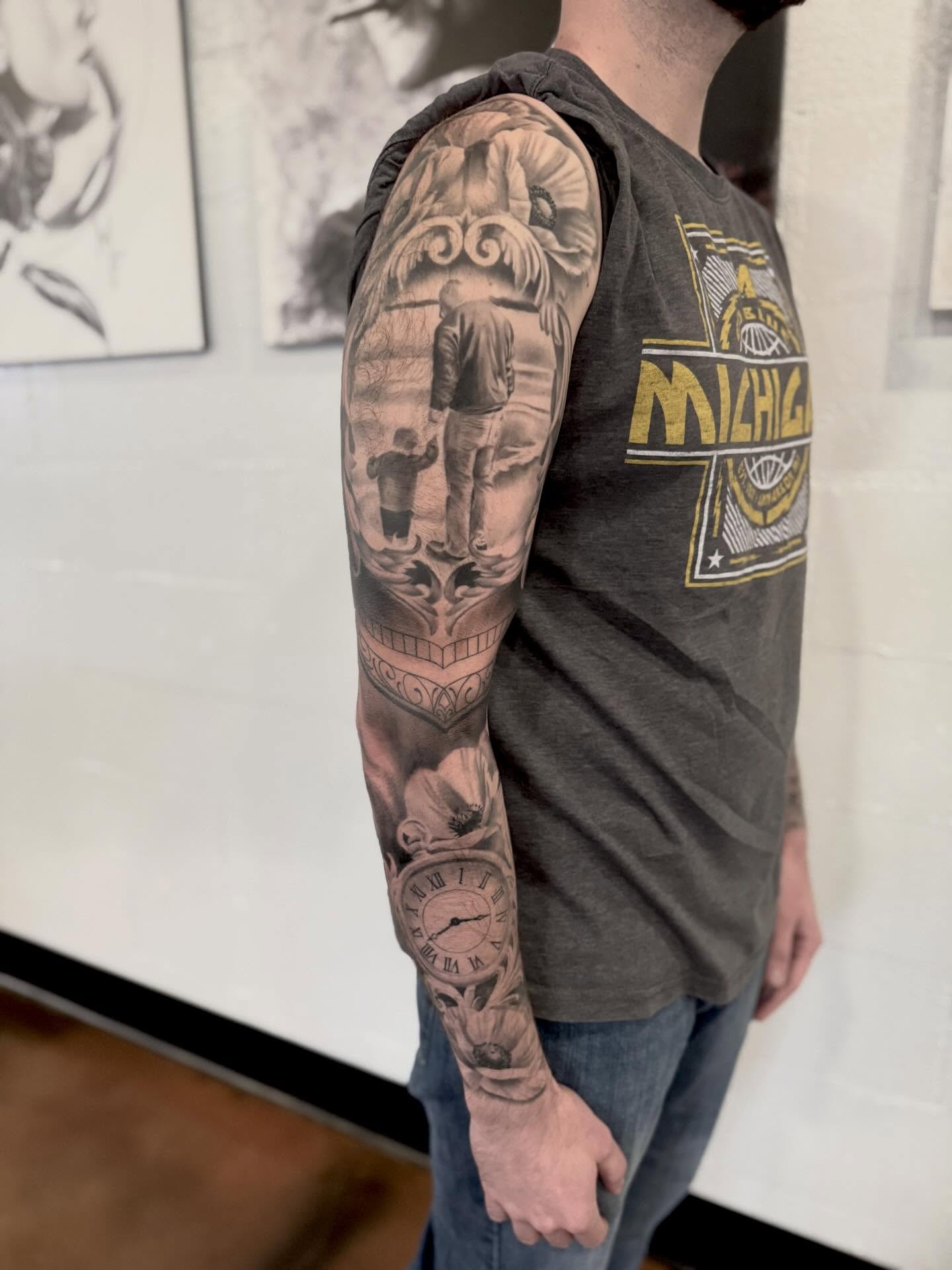 Family scene realism tattoo on the upper arm by Drew Foster, Toledo, Ohio