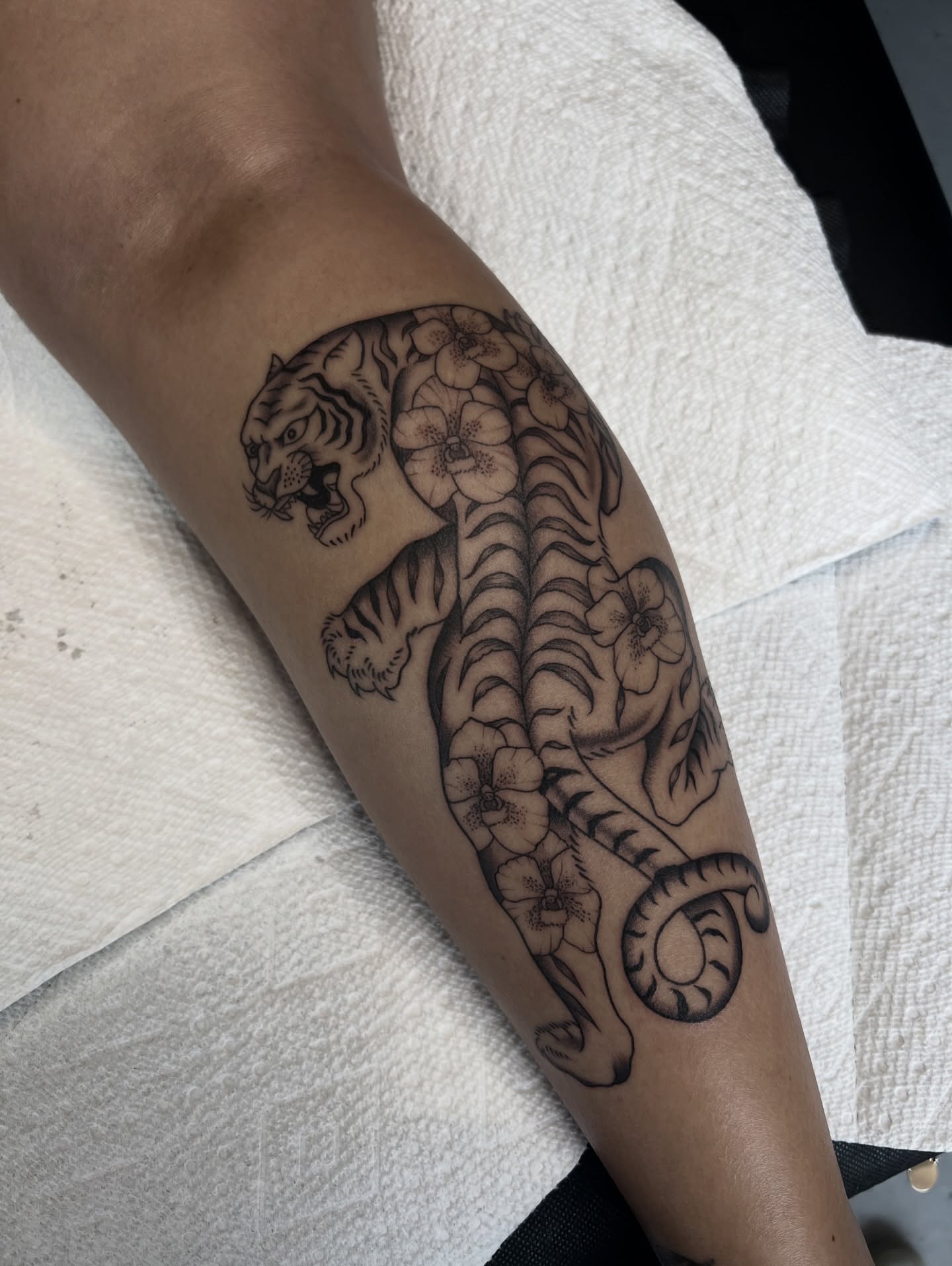 Tiger with flowers black and grey tattoo on the forearm by ✶ H A N N A H K A y ✶