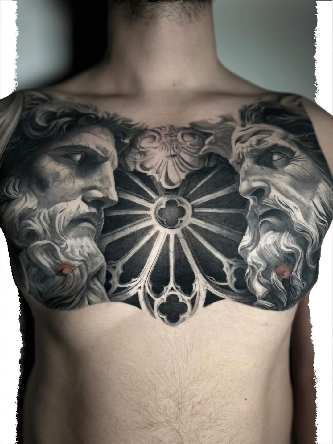 Two sculpted heads and rose window realism tattoo on the chest by Eltche Art Tattoo