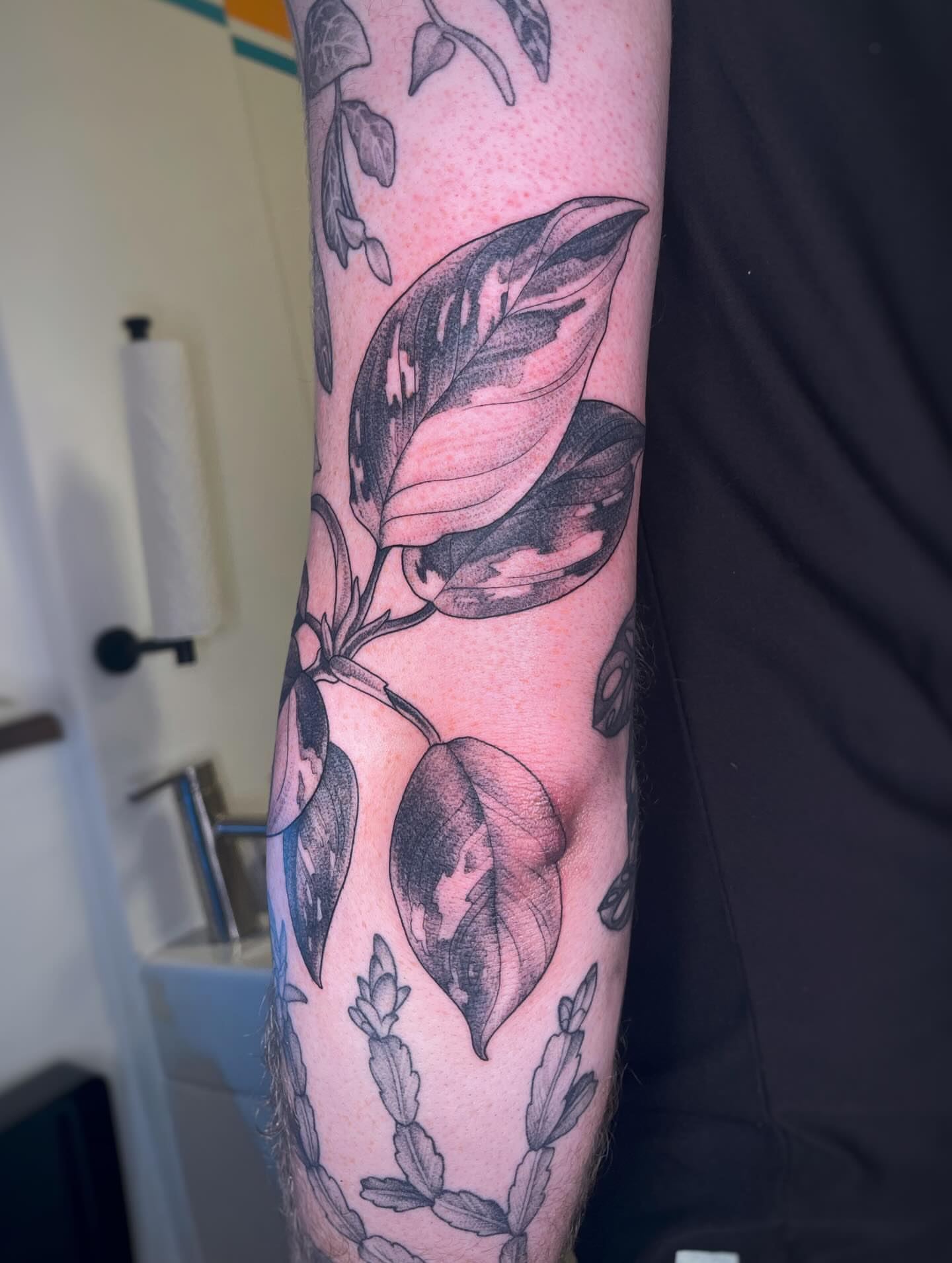 Leaf black and grey tattoo on the forearm by Emi Collison