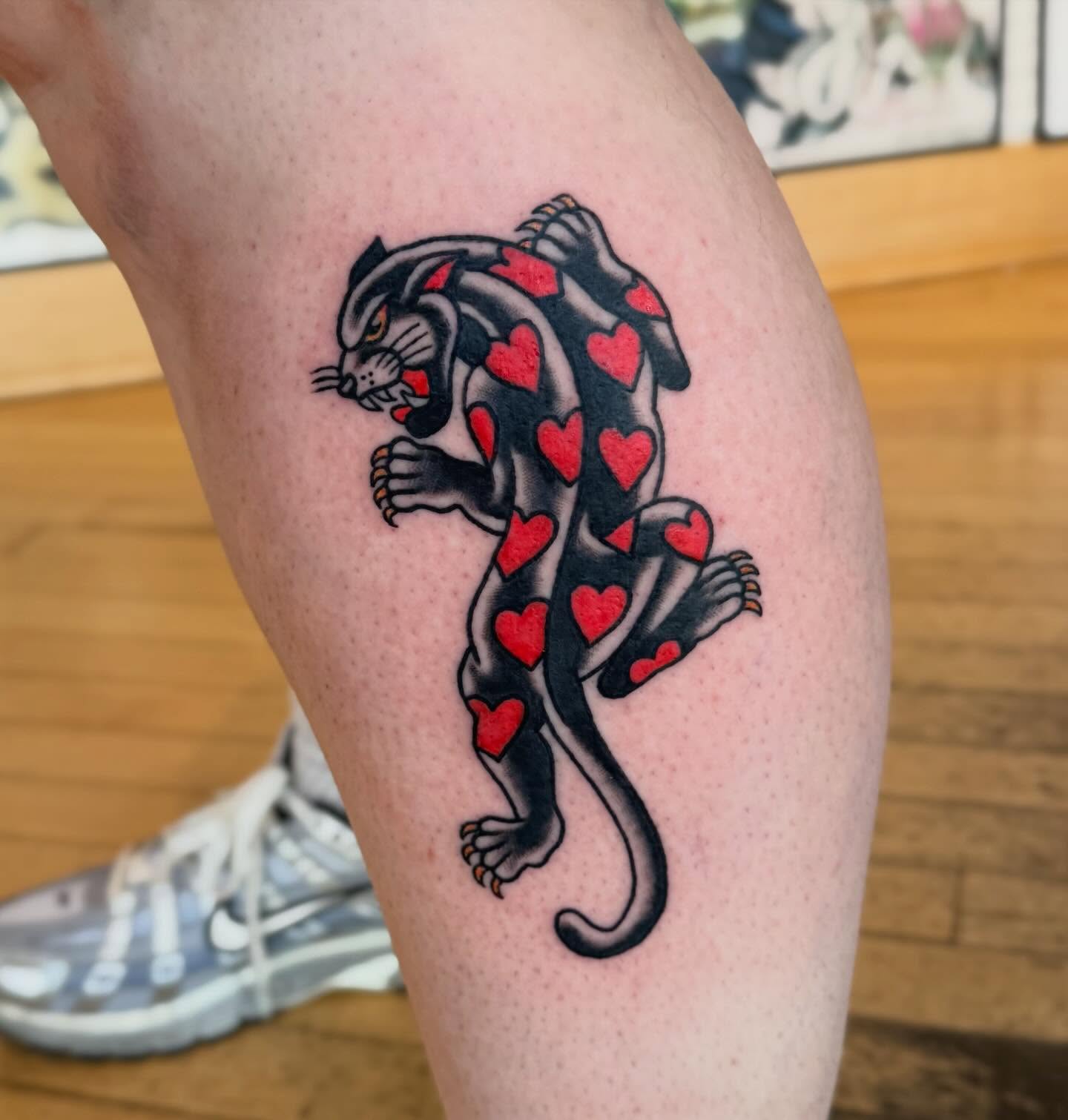 Panther with hearts American traditional tattoo on the thigh by Elle Yax