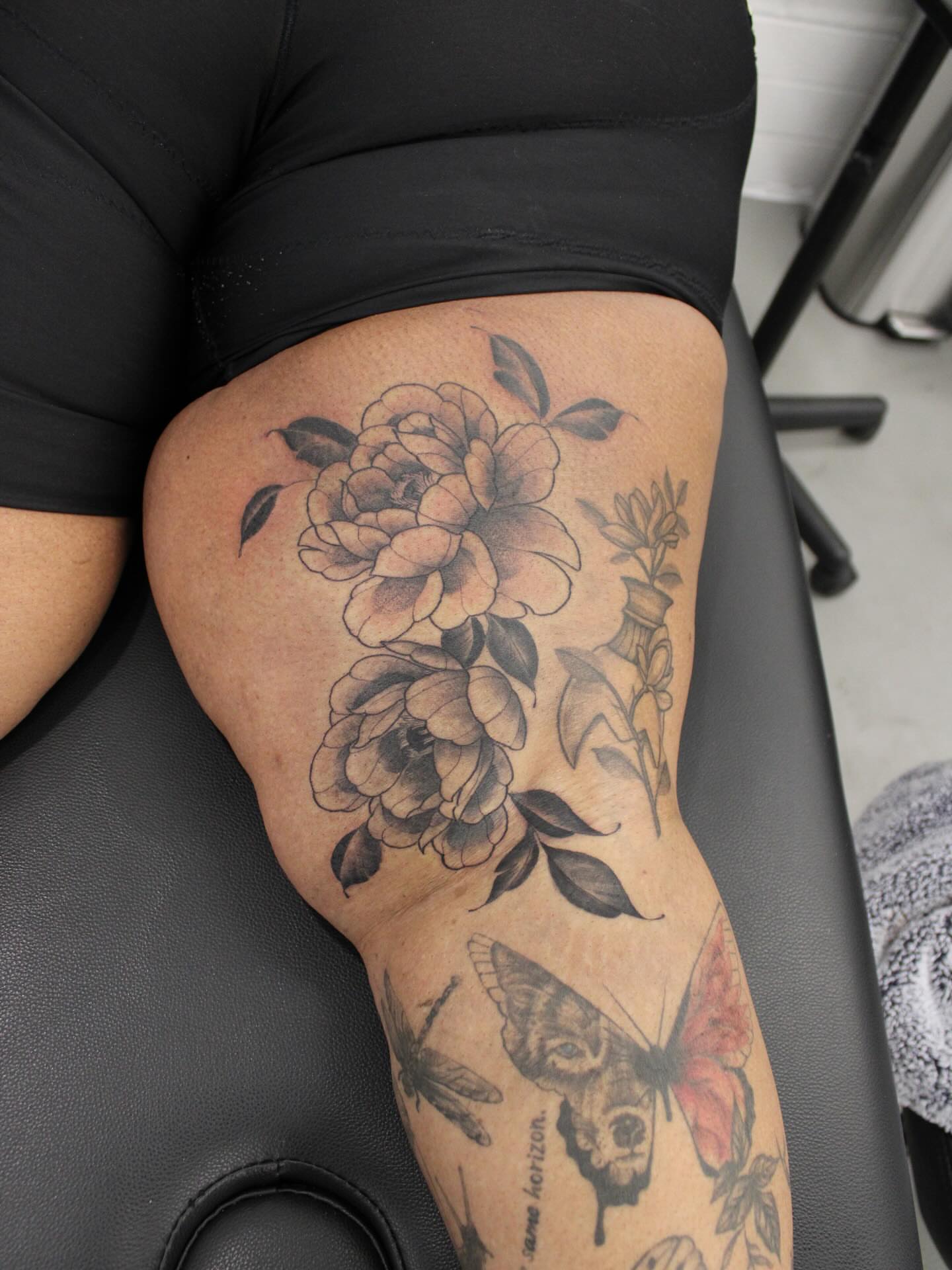 Peony bouquet realism tattoo on the thigh by Julianna