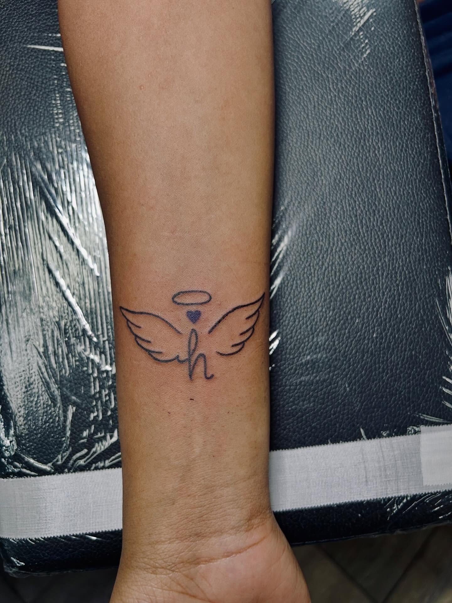 Angel wings minimalist tattoo on the forearm by Bjorn Bjornstad, Dubuque, Iowa