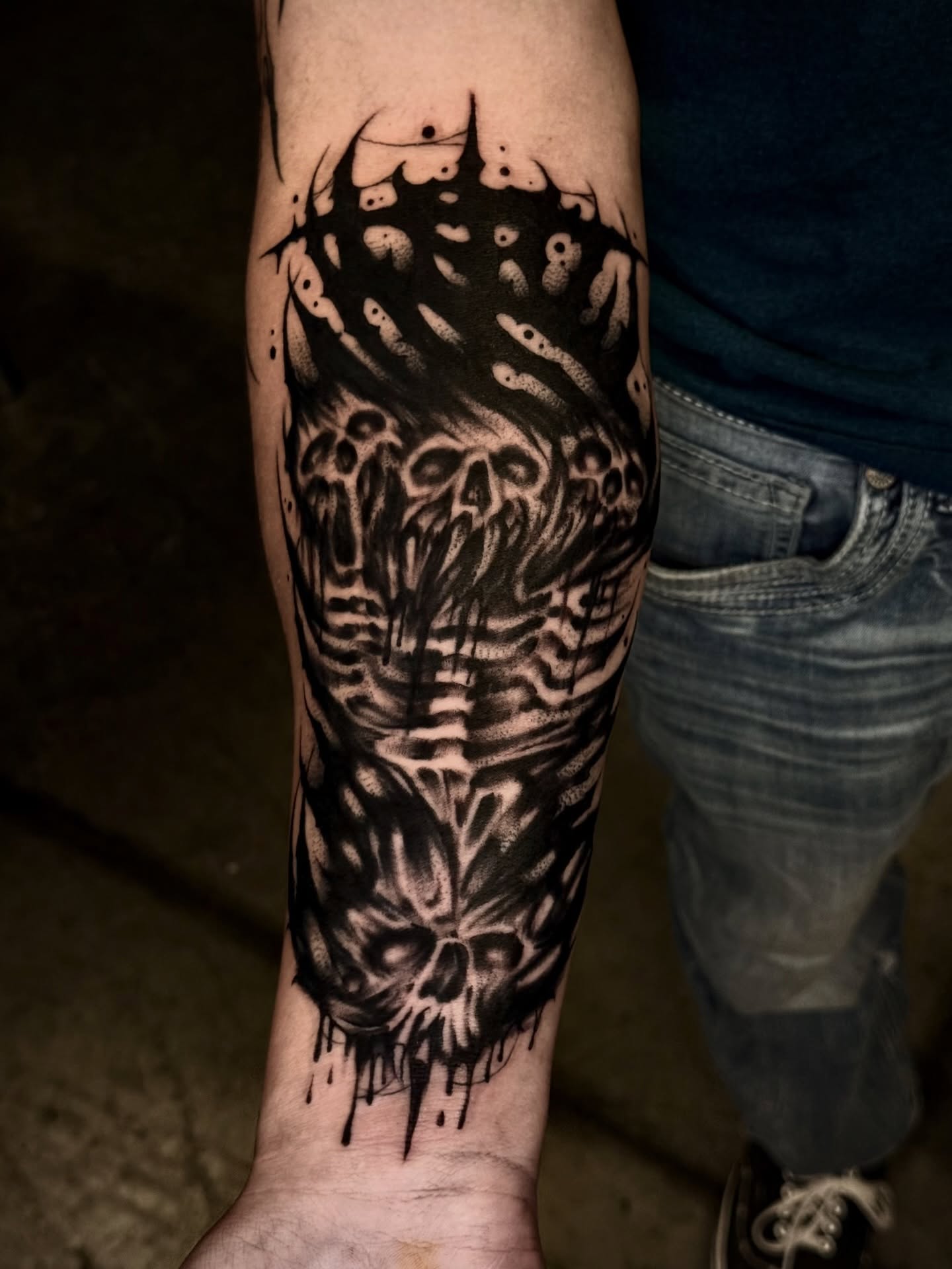 Skulls and bones dark realism tattoo on the forearm by Thomas Martinez