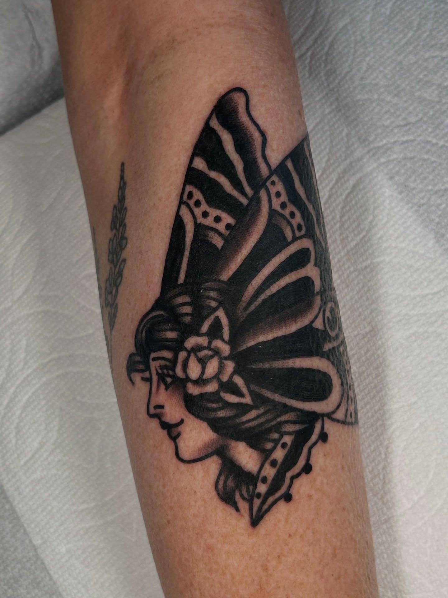 Woman's profile with headdress American traditional tattoo on the forearm by β π€ππ©π¦π©π’π β± β