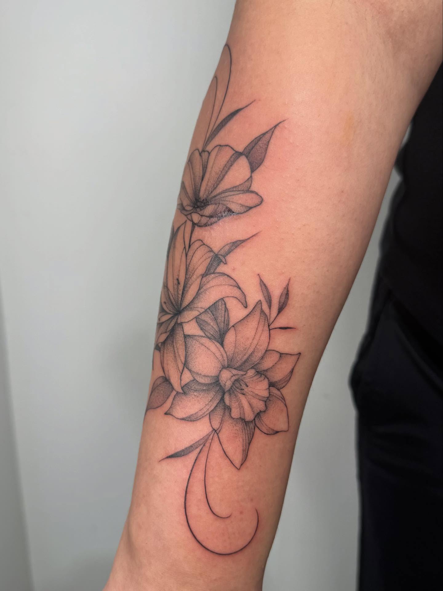Flowers black and grey tattoo on the forearm by Danae Andino