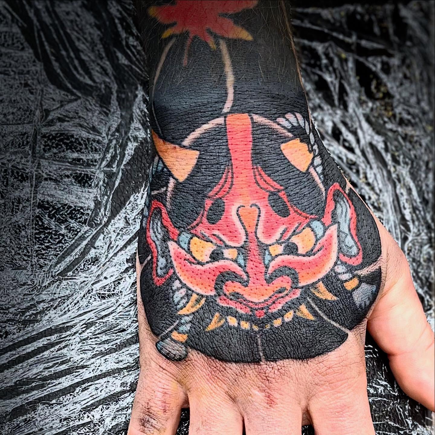 Demon mask American traditional tattoo on the hand by Tyler Howard