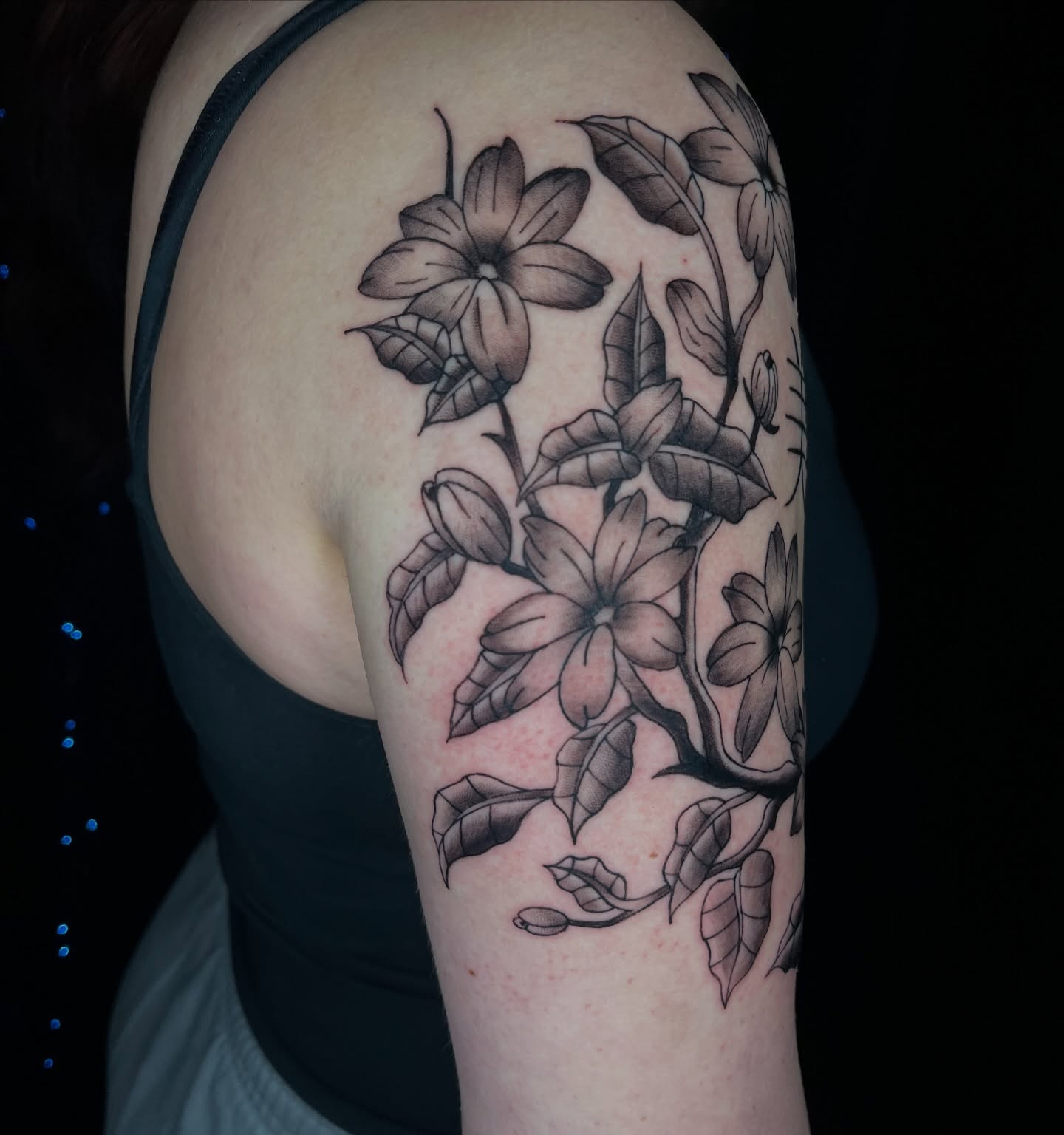 Flower vine black and grey tattoo on the upper arm by Brian Easlon
