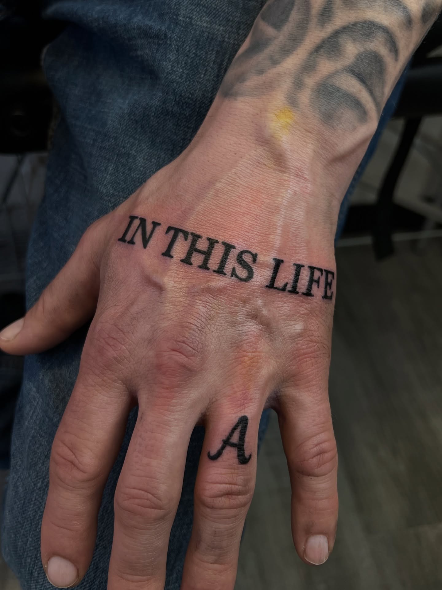In this life black and grey tattoo on the hand by Riley