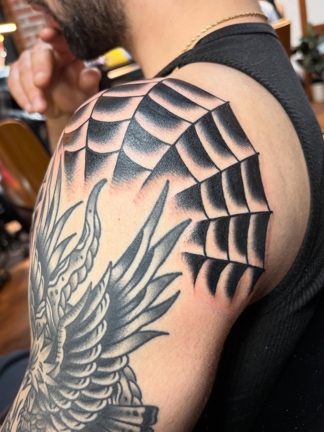 Spider web and eagle blackwork tattoo on the shoulder by Tom Wenzell