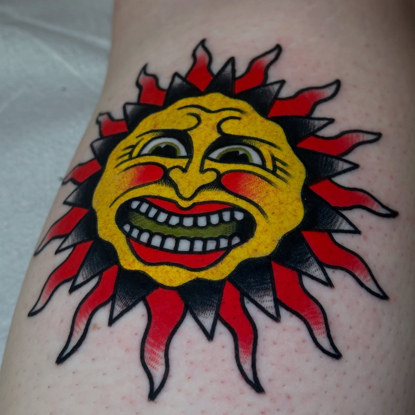 Sun American traditional tattoo on the thigh by Christian Rieben