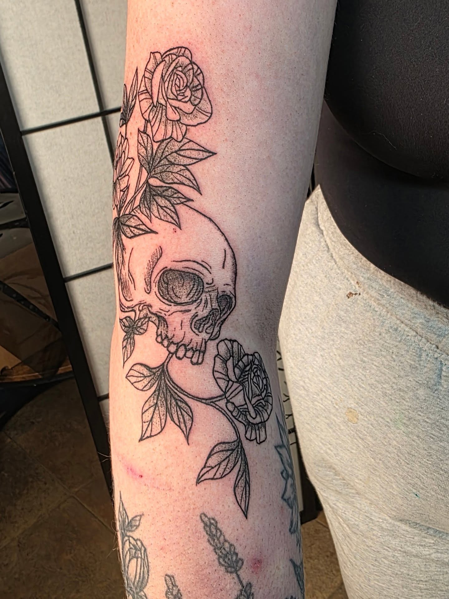 Skull and roses black and grey tattoo on the forearm by Bryan "Yogi" Fuhs